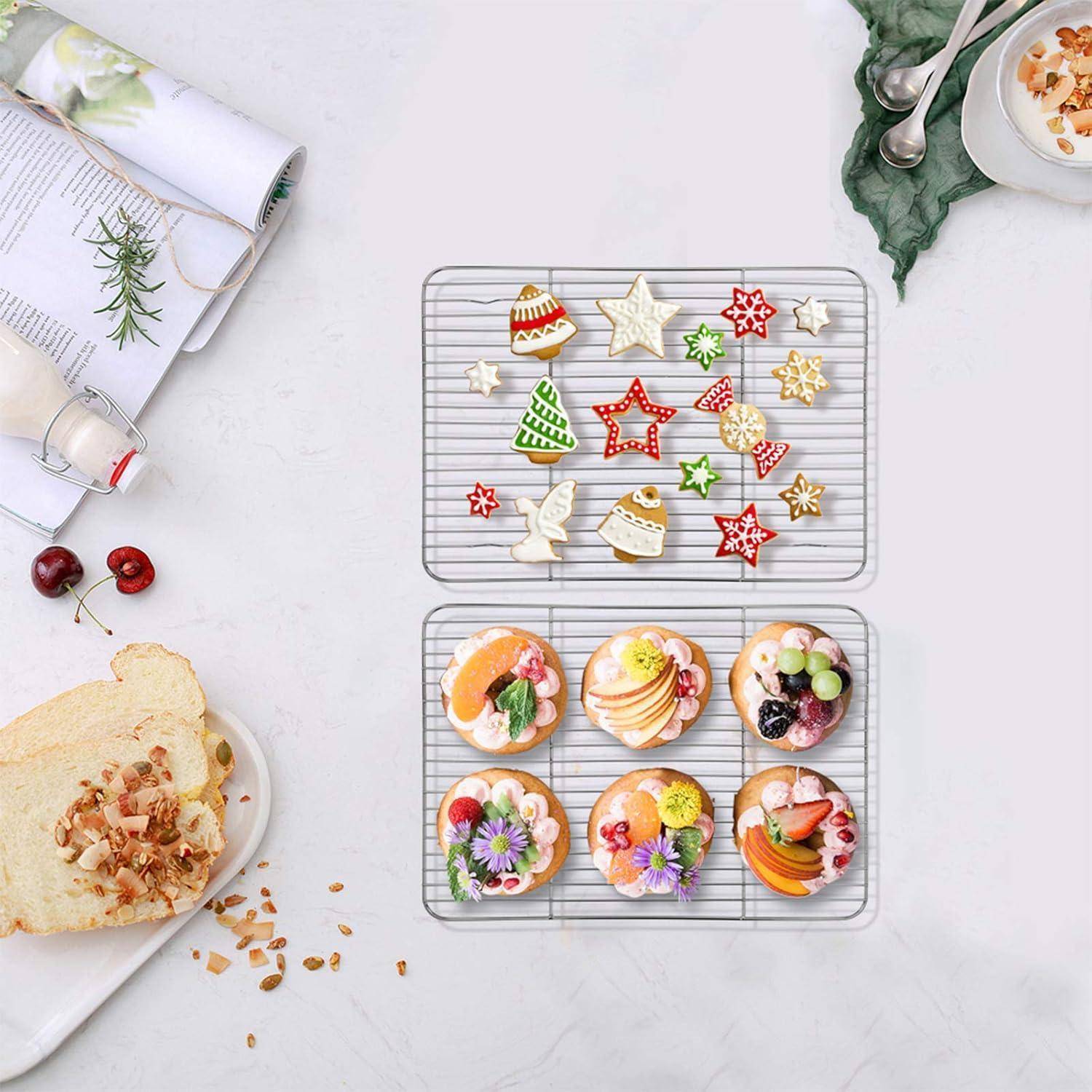 Eine Backszene mit dekorierten Festtagsplätzchen und fruchtig belegten Muffins auf Kühldrahtgestellen. Daneben liegt auf einem Schneidebrett eine Scheibe Brot und einige Kirschen.