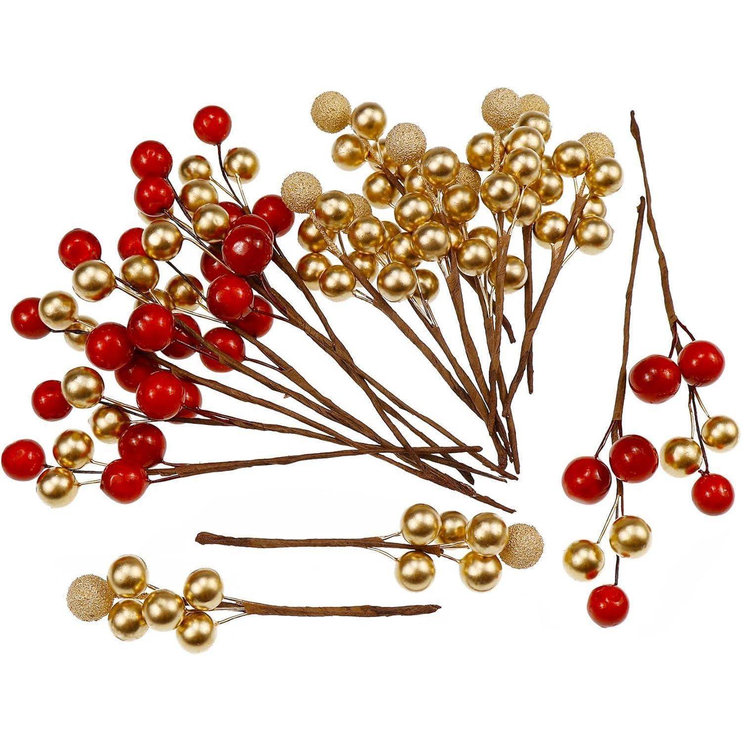 Rote und goldene künstliche Beerentrauben, in einem verstreuten Muster angeordnet, die dekorative Feiertagsakkzente auf braunen Stängeln nachahmen.