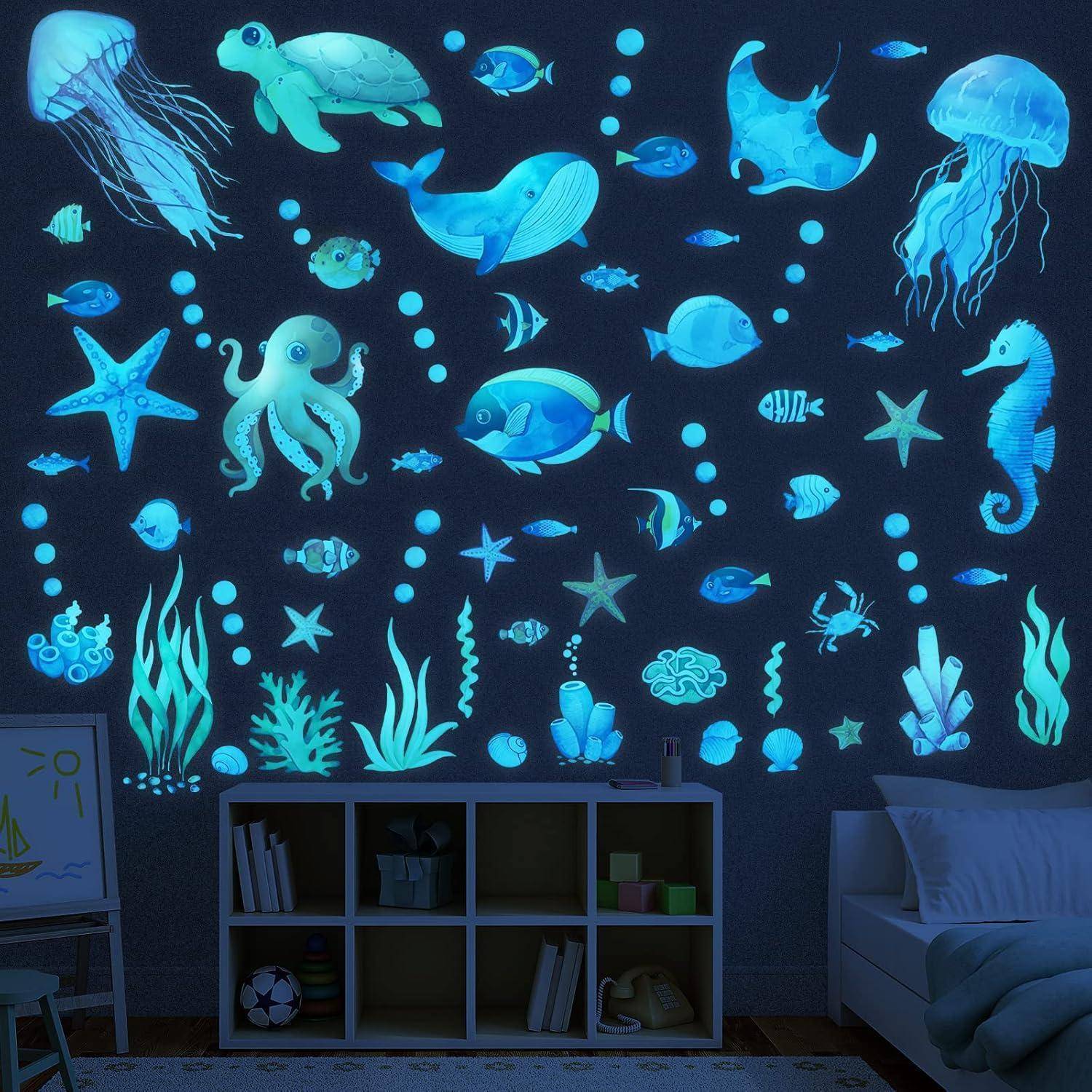Zimmerwand mit leuchtenden Meeresmotiv-Aufklebern: Quallen, Schildkröten, Wale, Fische, Tintenfisch, Seetang und Sterne, die eine maritime Atmosphäre erzeugen.