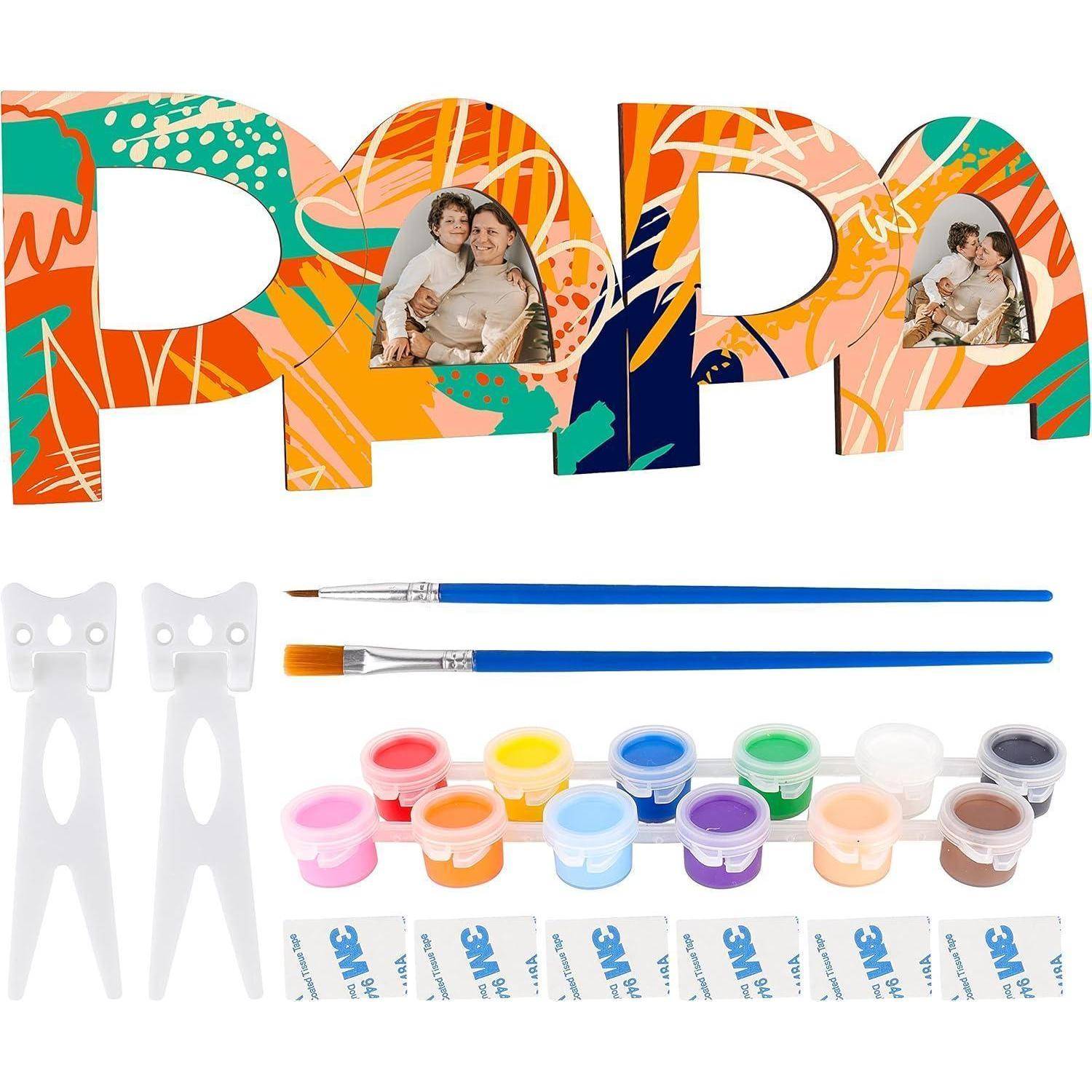 Malen-nach-Zahlen-Set mit farbenfrohen 'Papa' Buchstaben, zwei Pinseln, Farbdosen darunter und Klebstreifen. Entwickelt zum Erstellen eines personalisierten Geschenks.