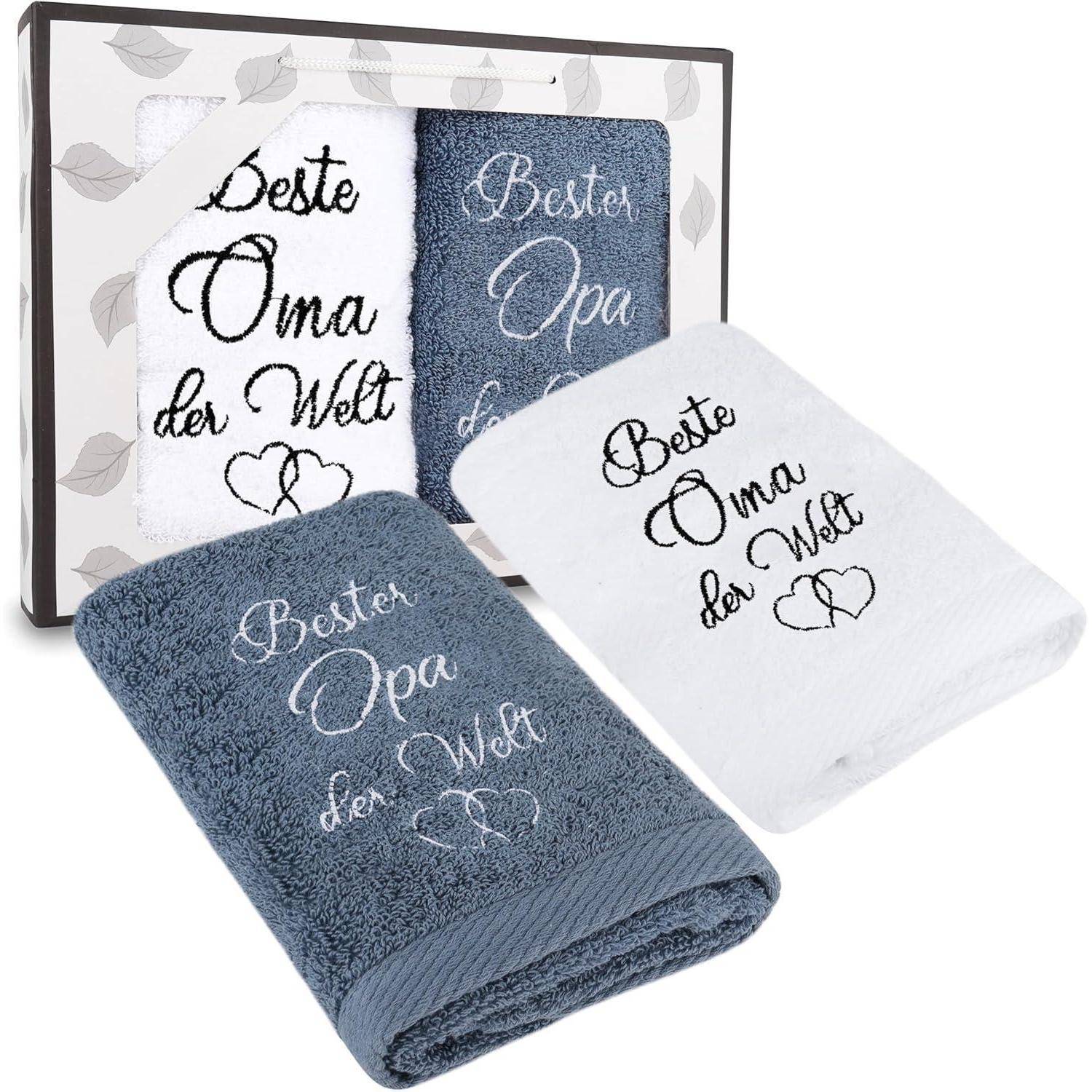 Ein Geschenkset mit zwei Handtüchern, eines weiß und eines blau, mit besticktem Text ‚Beste Oma der Welt' und ‚Bester Opa der Welt'.
