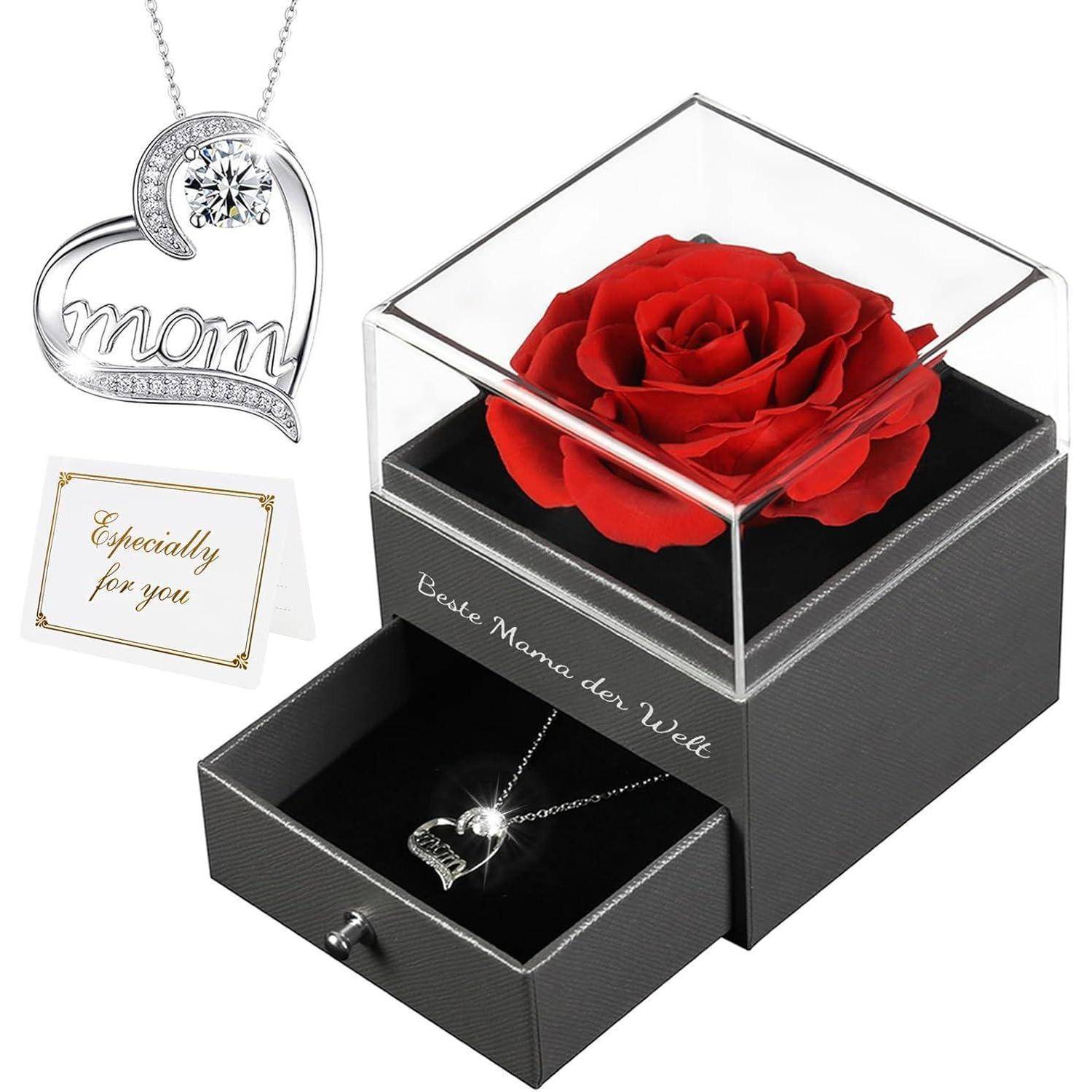 Eine rote Rose in einer durchsichtigen Box sitzt auf einem schwarzen Schmuckkästchen mit einer herzförmigen 