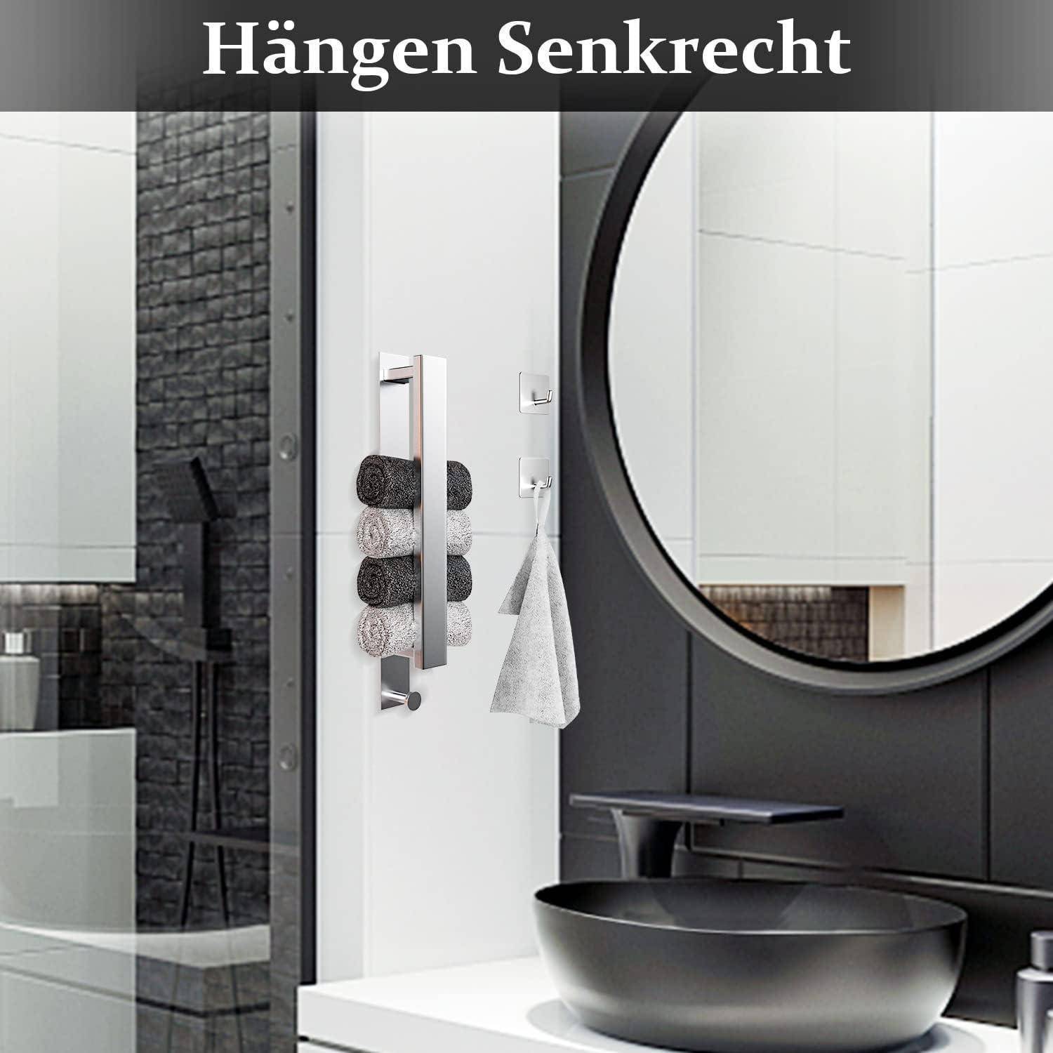 Ein schlankes Badezimmer mit einem schwarzen runden Spiegel, modernem Wasserhahn und einer vertikalen Handtuchstange, die aufgerollte Handtücher und ein hängendes Handtuch trägt.