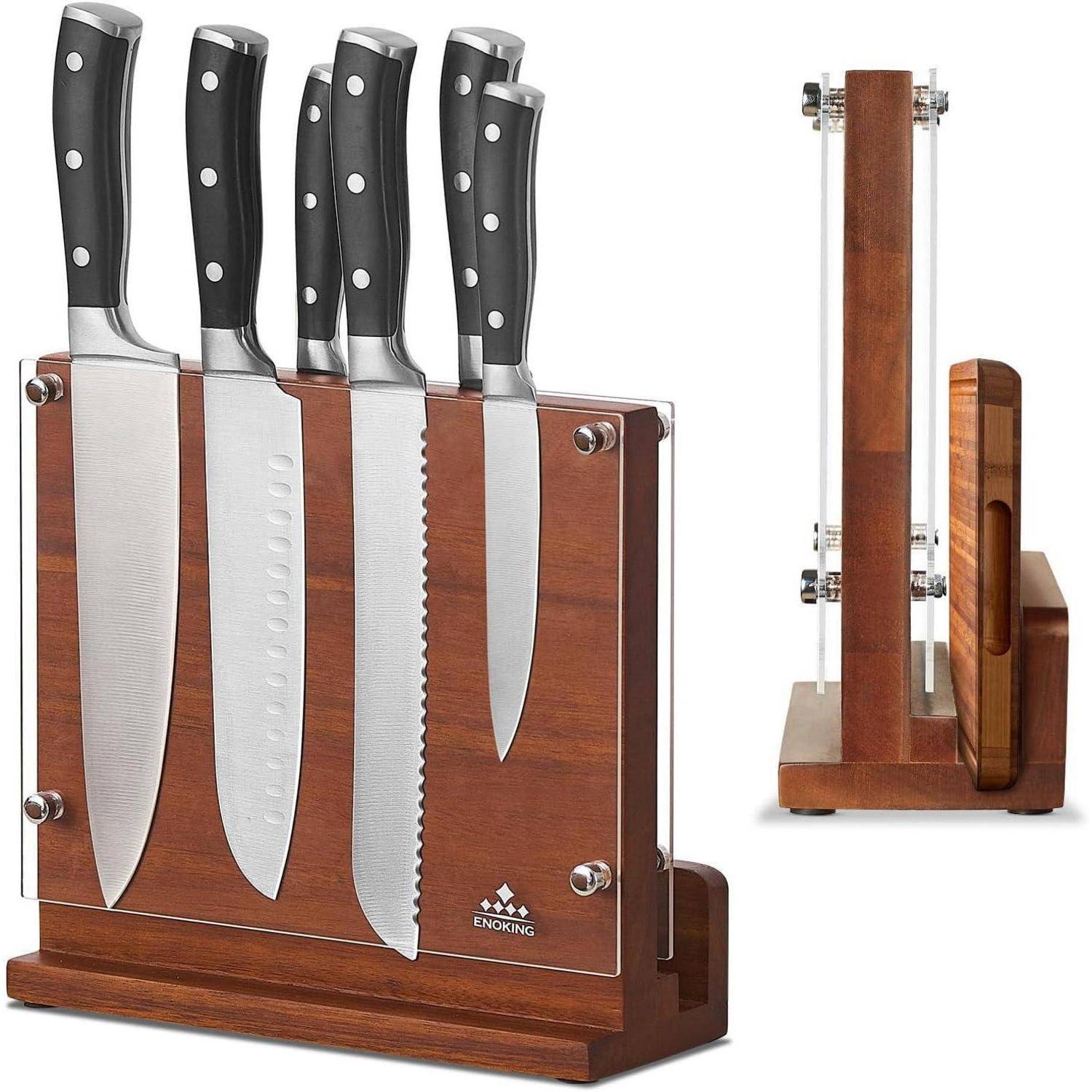 Ein Set aus fünf Küchenmessern mit schwarzen Griffen in einem Messerblock aus Holz und transparentem Acryl, das verschiedene Klingentypen präsentiert, darunter ein Kochmesser und ein Sägemesser.