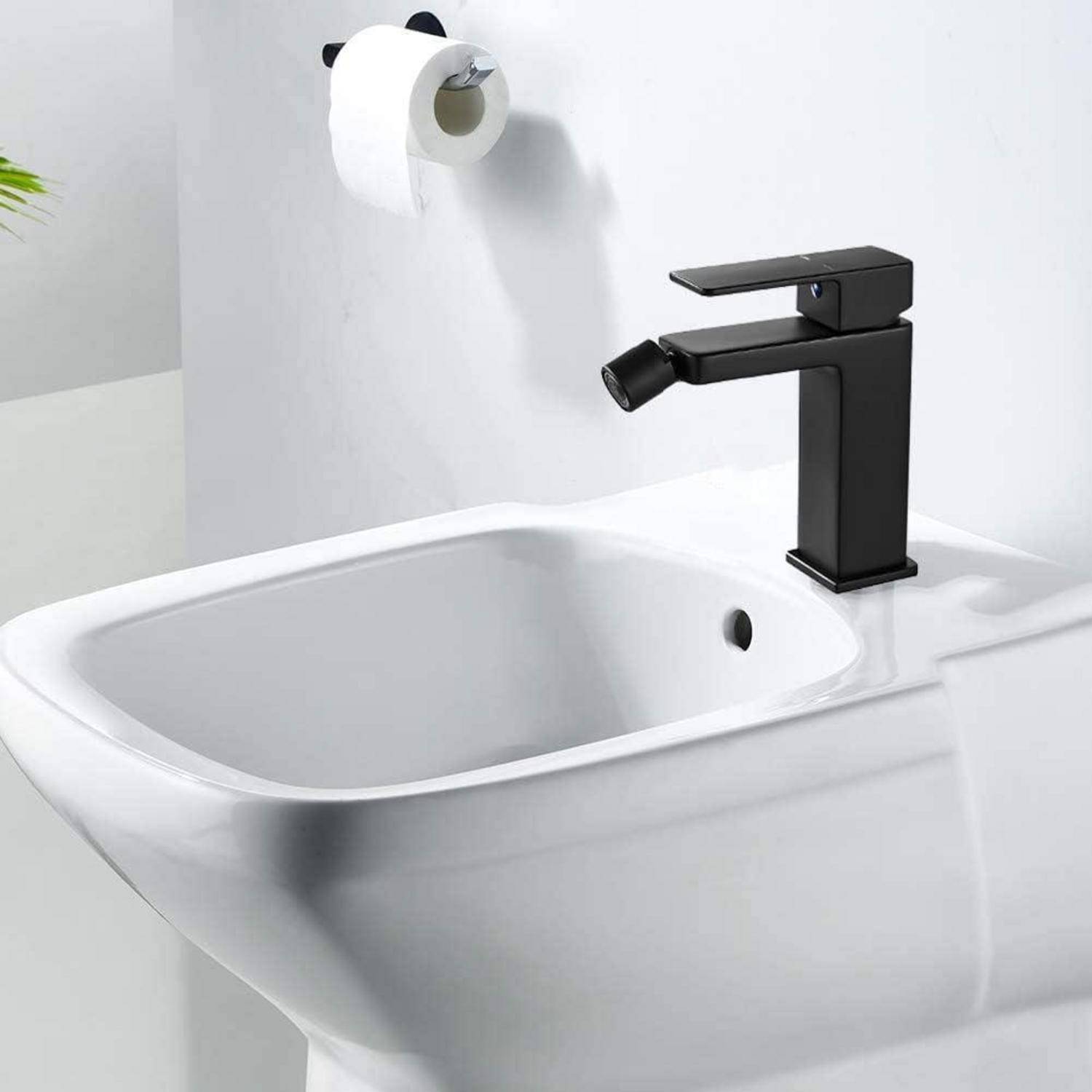 Eine moderne schwarze Badezimmerarmatur auf einem weißen Waschbecken, mit einem wandmontiertem Toilettenpapierhalter im Hintergrund.