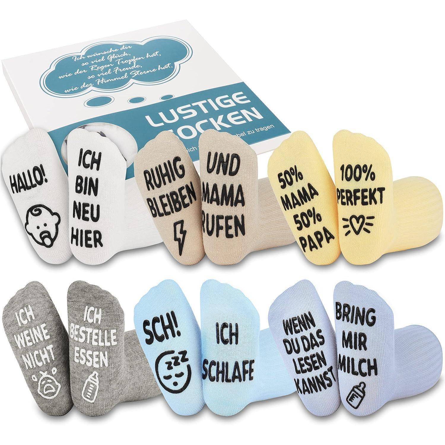 Ein Set bunter Babysocken mit deutschen Phrasen wie 'Hallo!', 'Ich bin neu hier' und 'Ruhig bleiben', die in einer Verpackungsbox präsentiert werden.