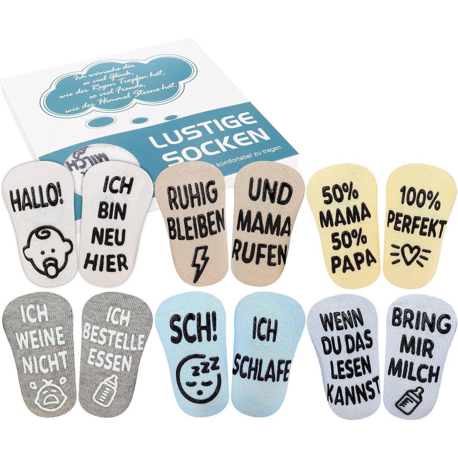 Ein Set bunter Socken mit humorvollen deutschen Phrasen wie ‚Hallo!', ‚Ich bin neu hier' und ‚Bring mir die Milch' darauf.