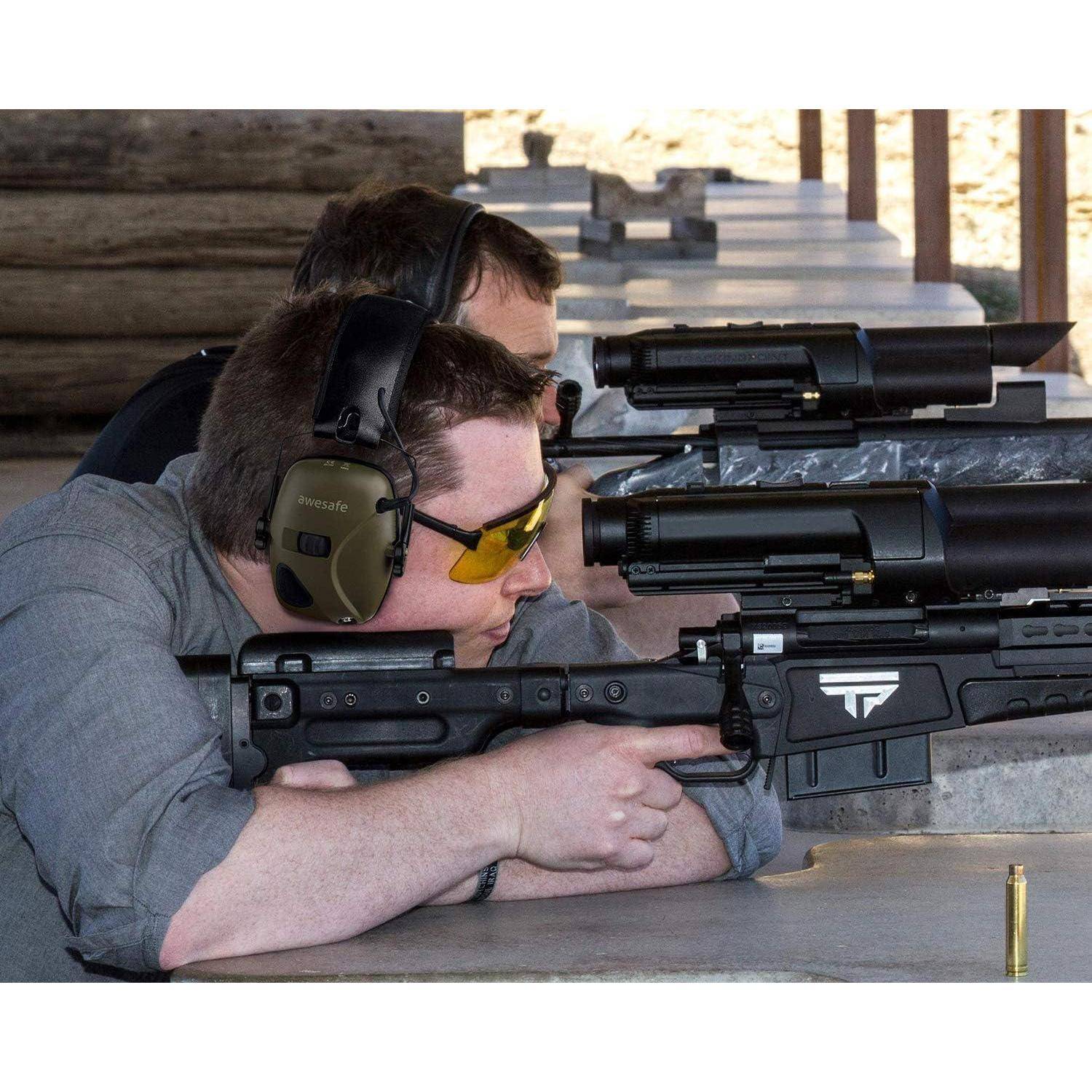 Zwei Personen mit Gehörschutz und Schutzbrille zielen mit Gewehren auf einem Schießstand und konzentrieren sich auf die Ziele in der Distanz.