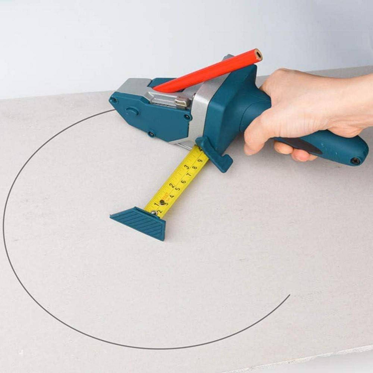 Eine Hand verwendet einen blauen Kreisschneider auf grauem Material und misst einen Kreis mit einem gelben Maßband. Das Werkzeug hat einen roten Griff.