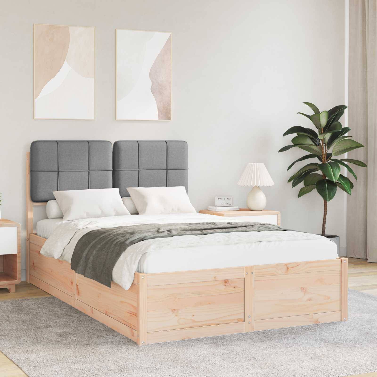Ein modernes Schlafzimmer mit einem Bettgestell aus Holz, grauem gepolstertem Kopfteil und grauer Decke. Zwei abstrakte Gemälde hängen über dem Bett.