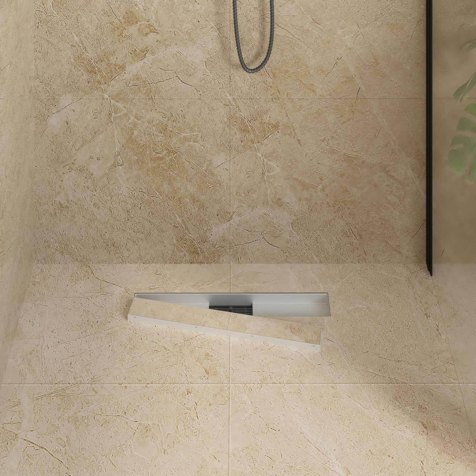 Eine minimalistische beige Dusche mit einer schlichten, abschüssigen Bodenfläche zur Entwässerung, ausgestattet mit einem silbernen Duschkopf und dezenter Marmorstruktur.
