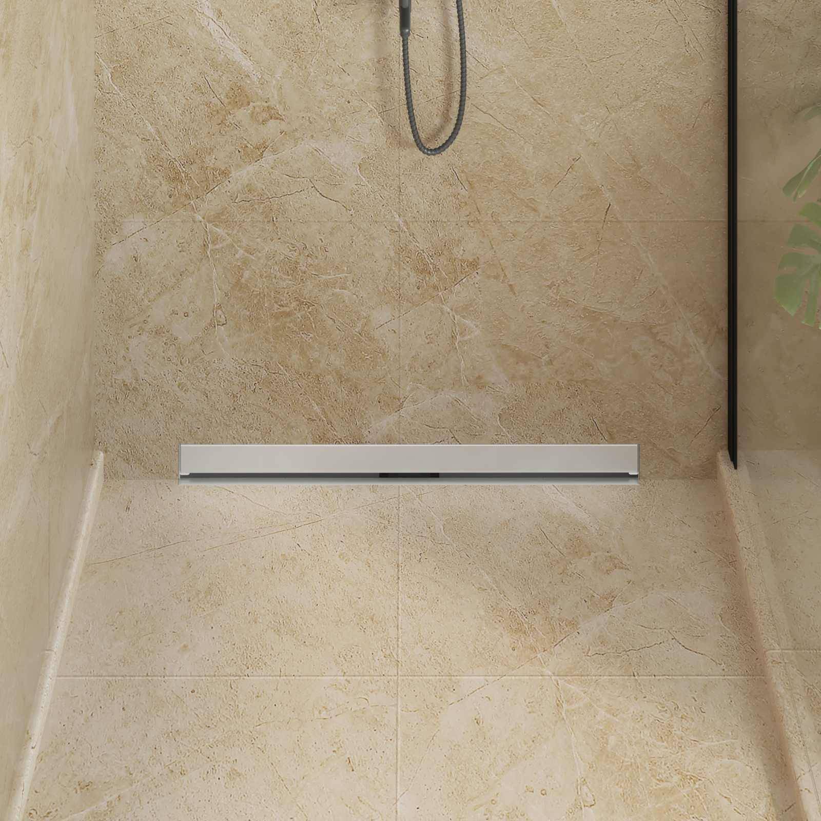 Eine moderne Dusche präsentiert ein schlankes, minimalistisches Design mit einer linearen Entwässerung auf einem marmorartigen Boden und beigen Wänden.