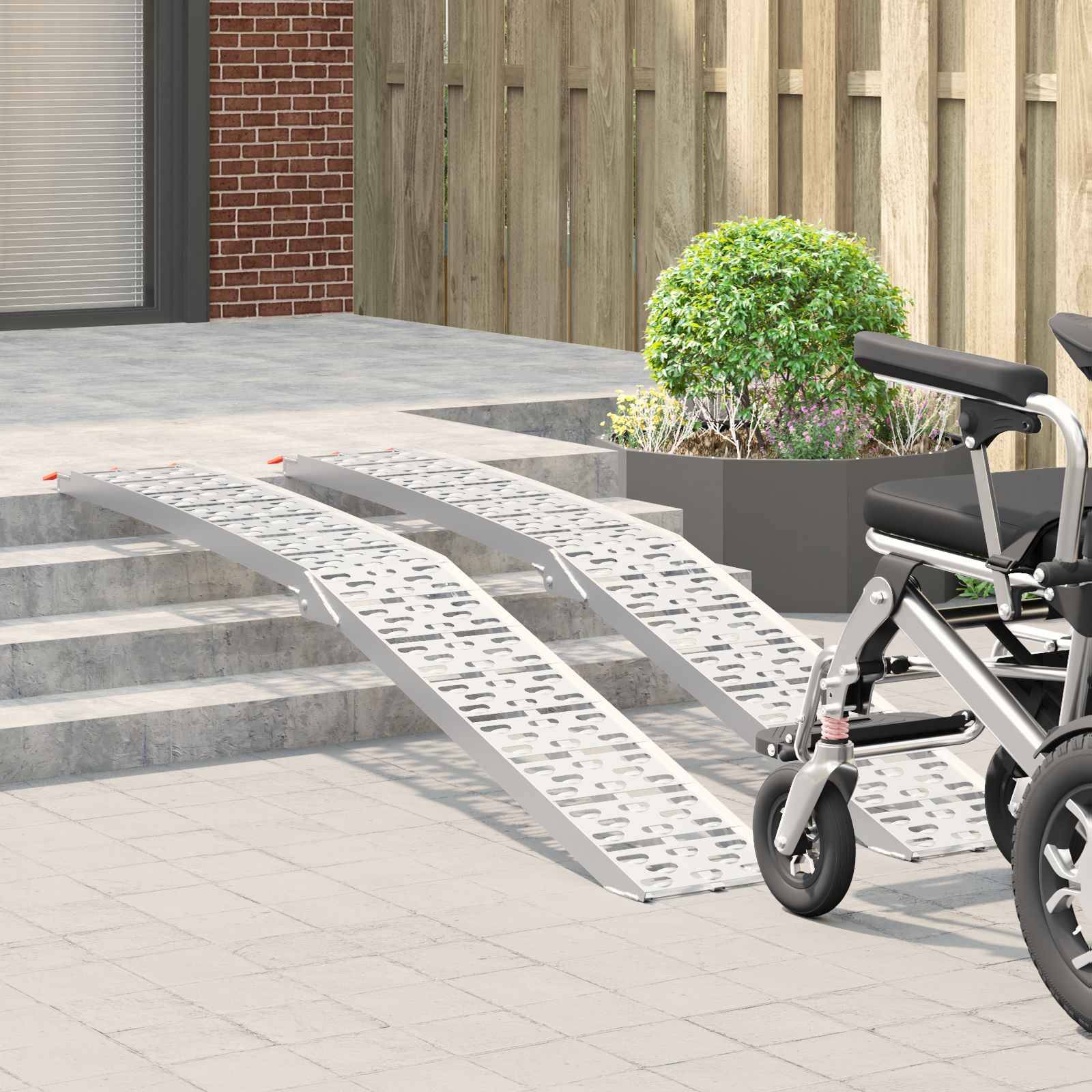 Ein Rollstuhl steht am Fuß einer Metallrampe, die zu einer kleinen Treppe hinaufführt und damit den barrierefreien Zugang zu einem Gebäude veranschaulicht.