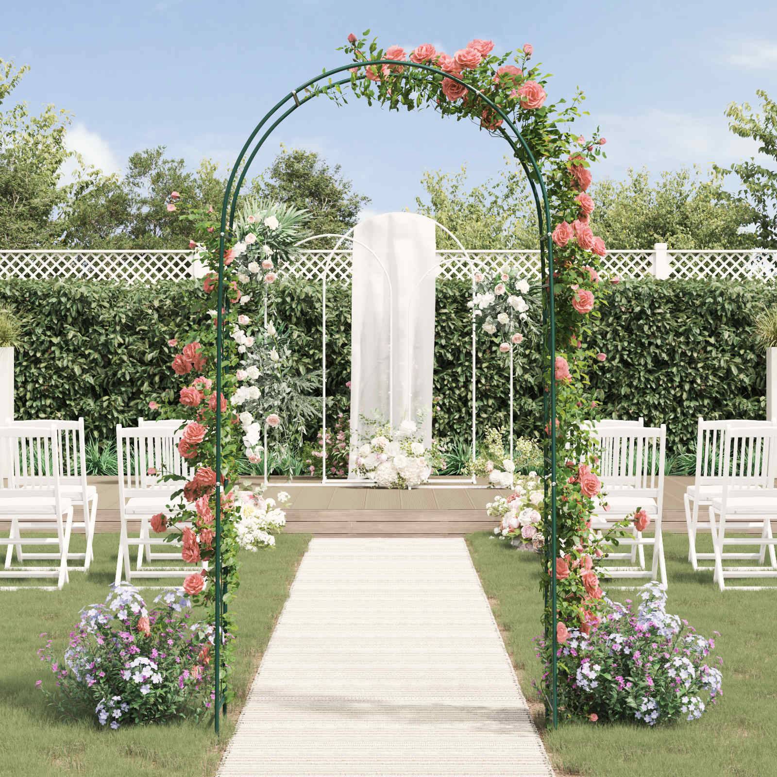 Eine Hochzeitsfeier im Garten mit einem Blumenbogen, weißen Stühlen und einem kleinen Altar im Hintergrund, eingebettet in üppiges Grün und Blumen.