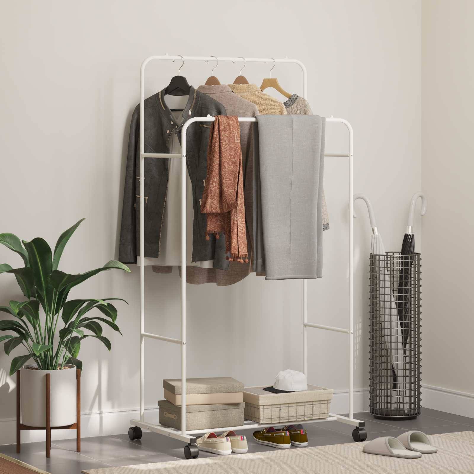Ein weißer Kleidungsständer auf Rollen trägt Jacken, Hemden und graue Hosen. In der Nähe stehen ein Topfpflanze und ein Golftasche auf einem beigen Teppich.