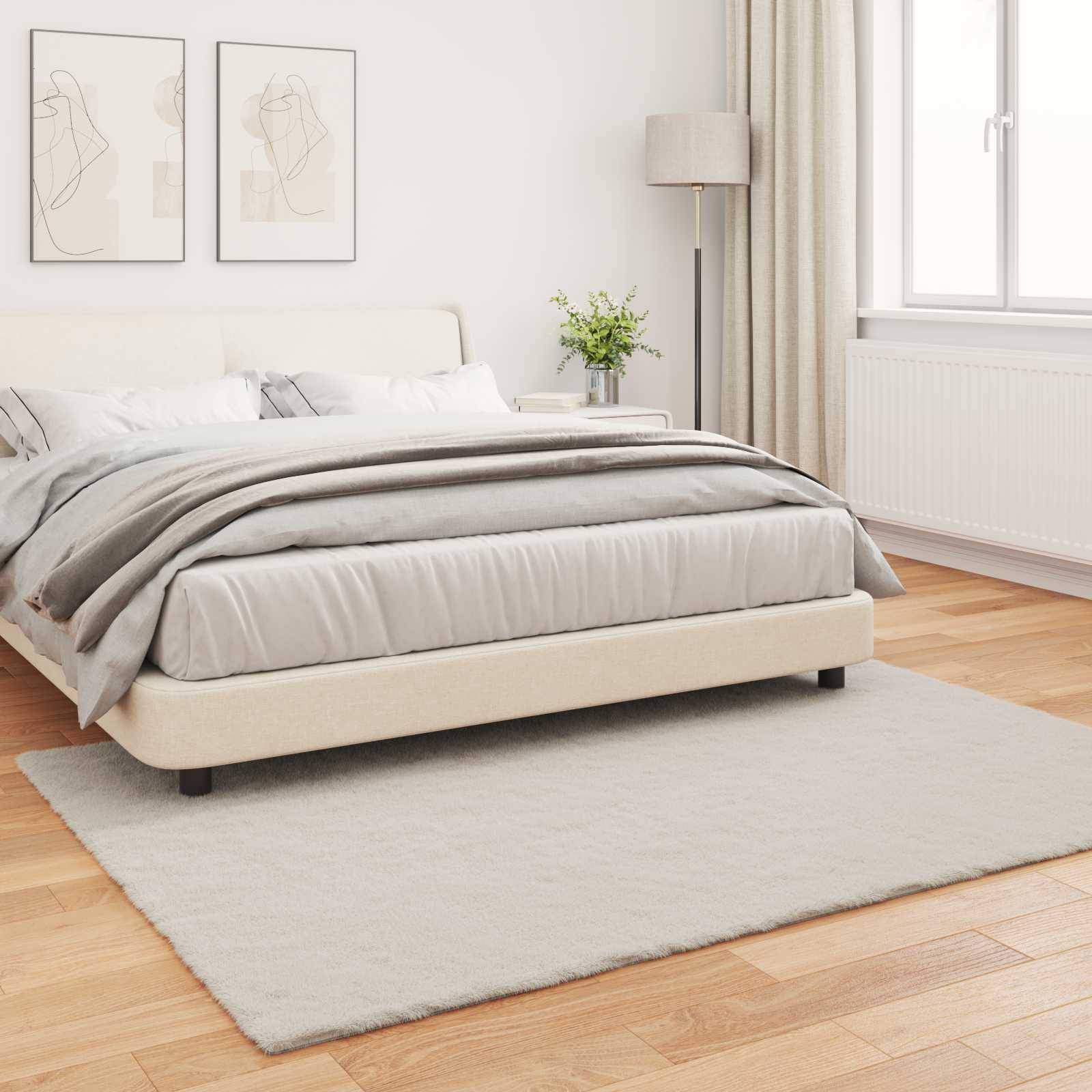 Ein minimalistisches Schlafzimmer mit einem Doppelbett, das mit neutraler Bettwäsche ausgestattet ist, zwei abstrakten Wandkunstwerken, einer Stehlampe und einem Fenster mit Vorhängen.
