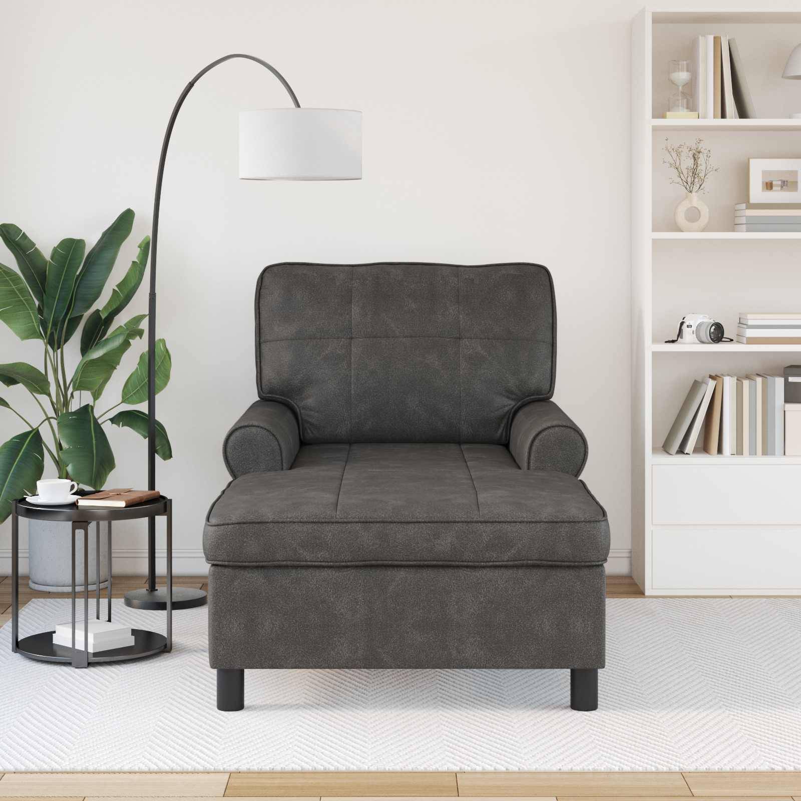 Ein modernes Wohnzimmer verfügt über einen dunkelgrauen Sessel mit gepolsterter Rückenlehne und Armlehnen, eine weiße Stehlampe und Regale mit Büchern und Dekorationen.