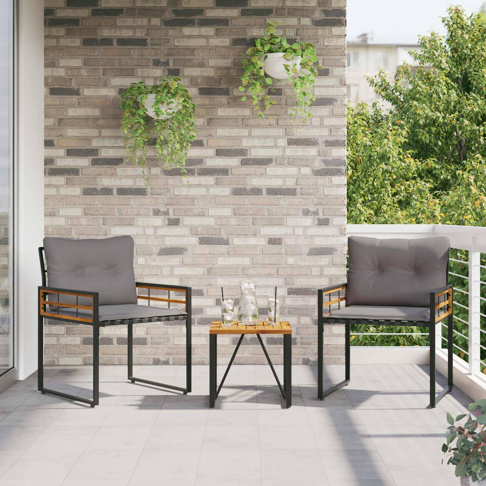 Eine Terrasse mit zwei grauen gepolsterten Stühlen und einem kleinen Holztisch dazwischen. Hängende Pflanzen schmücken die Ziegelwand, und Grünpflanzen sind zu sehen.