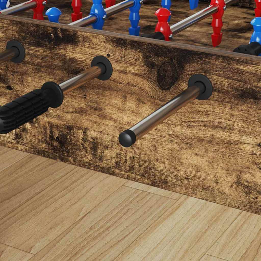 Kickertisch auf einem Holzboden, der rote und blaue Spielfiguren auf Metallstangen zeigt.