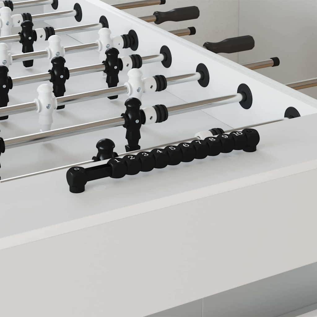 Ein moderner Kickertisch mit schwarzen und weißen Spielfiguren auf Metallstangen, bereit für ein Spiel. Die Stangen verfügen über Griffe, und ein Punktezähler ist zu sehen.