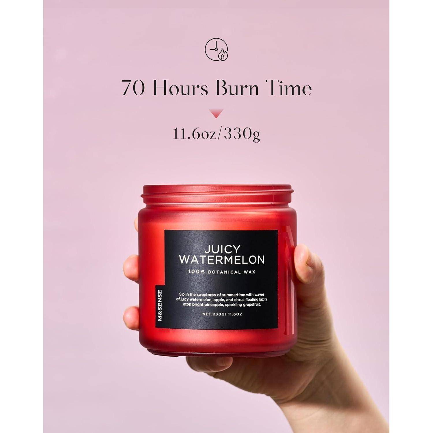 Hand mit einer roten Kerze mit der Aufschrift „Juicy Watermelon, 100% Botanisches Wachs, 11.6oz/330g, 70 Stunden Brenndauer