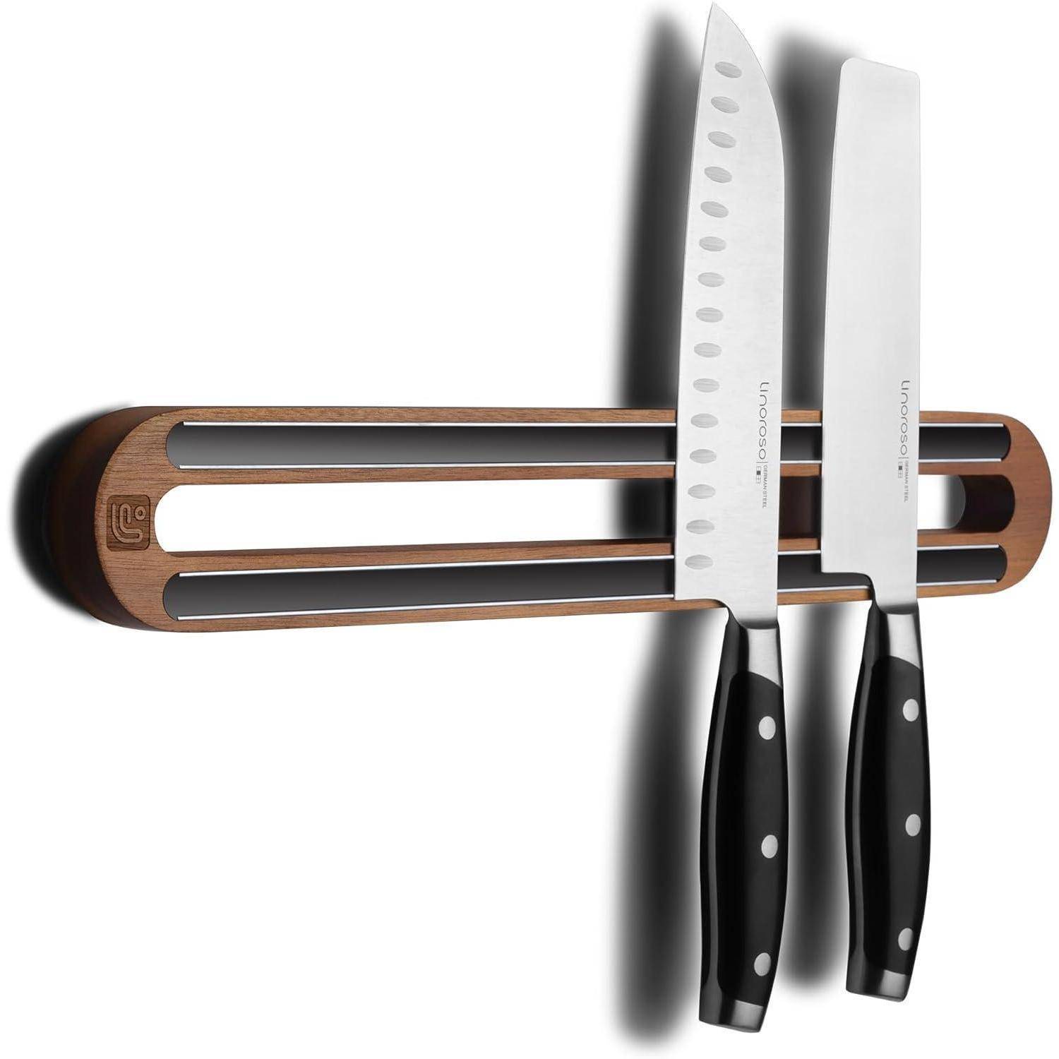 Ein magnetischer Messerhalter mit zwei Messern: einem Kochmeser und einem Tranchiermesser. Der Halter ist aus Holz und an einer weißen Wand montiert.