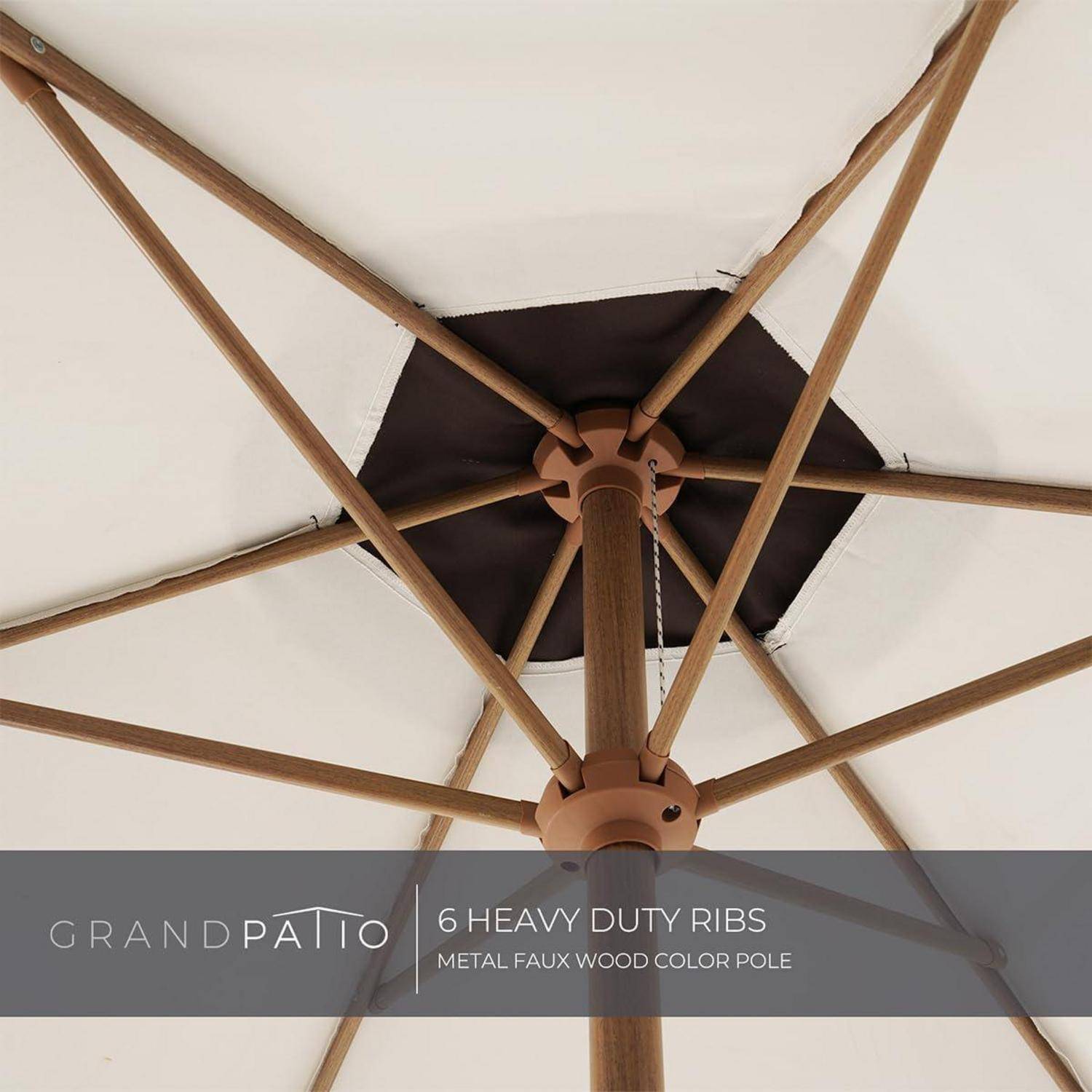 Ein Außenschirm mit einem Holzstiel und sechs robusten Streben, der eine Metalloberfläche in Holzoptik präsentiert. Der Markenname 'Grand Patio' ist sichtbar.