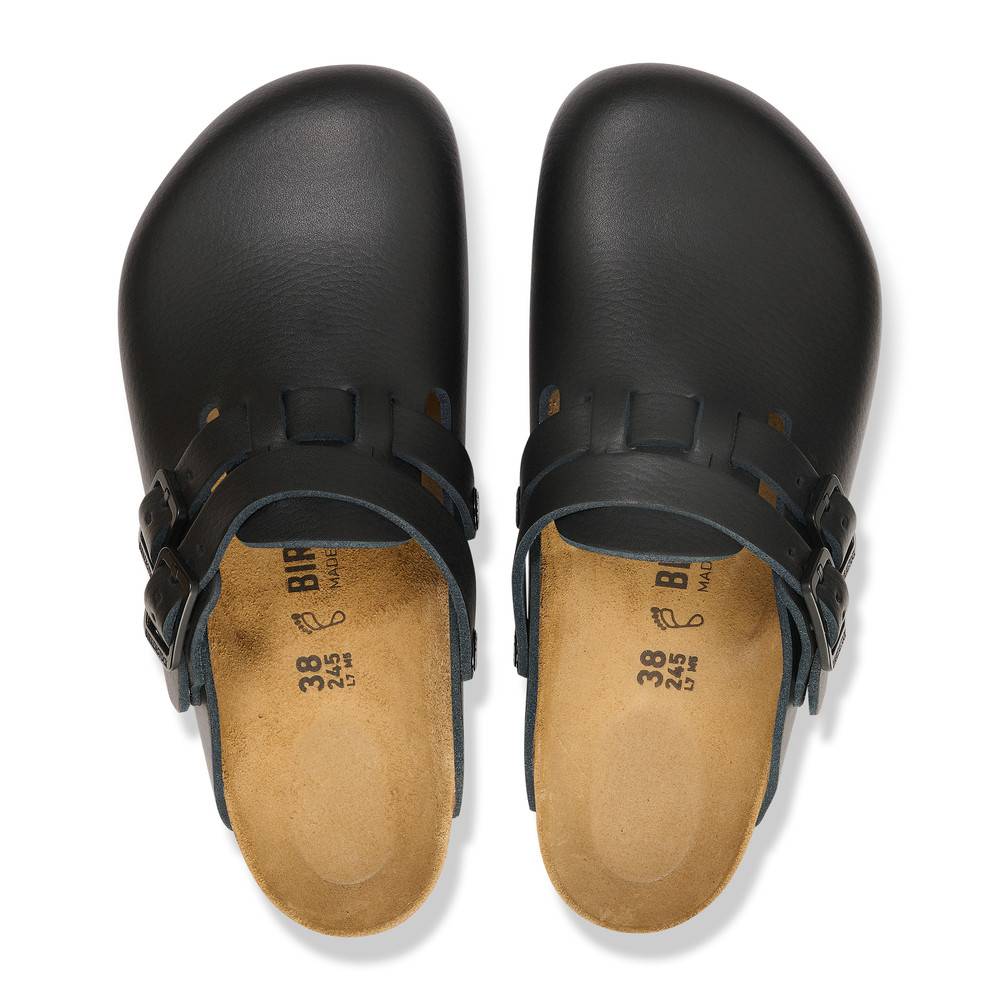 Schwarze Holzschuhe mit verstellbaren Riemen und Korkeinlagen, von oben betrachtet.