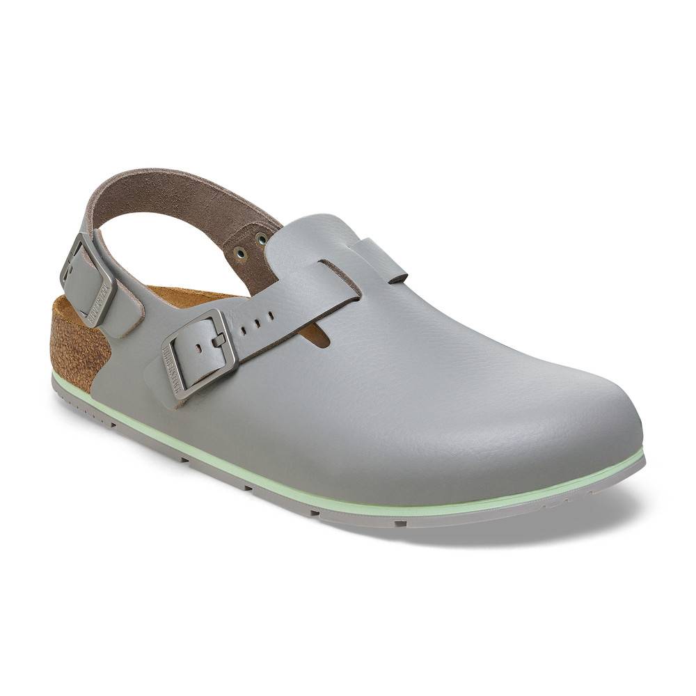 Ein einzelner grauer Clog-Schuh mit verstellbarem Schnallengurt, Korkeinlage und grün abgesetzter Sohle.
