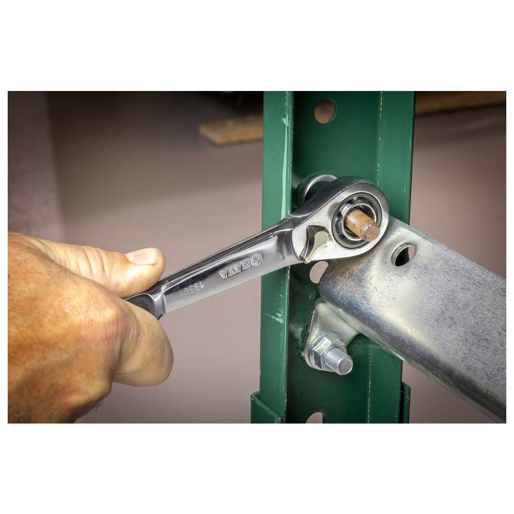 Eine Hand zieht eine Metallschraube mit einem Ratschenschlüssel auf einem grünen Metallrahmen fest und befestigt einen horizontalen Metallträger an einer vertikalen Stütze.