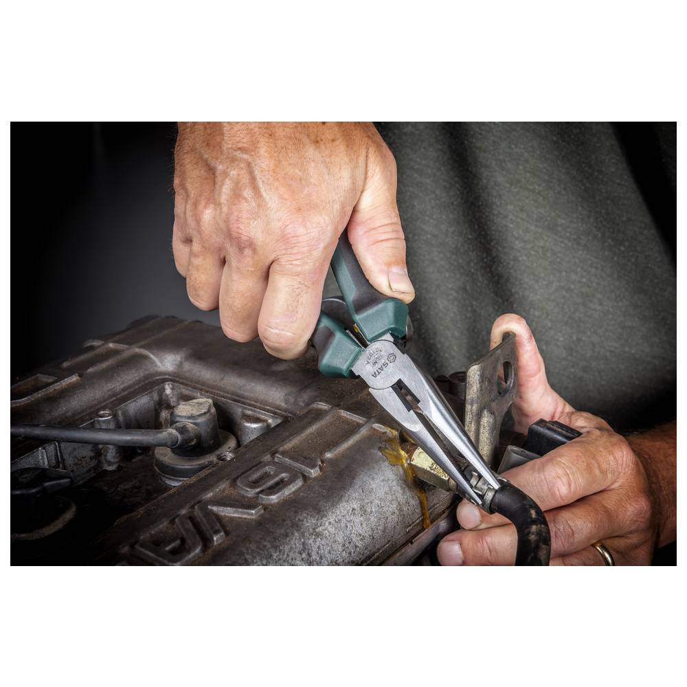 Hände, die mit einer Zange einen Draht in der Nähe eines Metallmotorteils greifen und dabei Fahrzeugwartung oder Reparaturarbeiten demonstrieren.