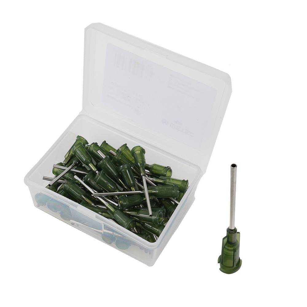 Eine kleine offene Plastikbox, die mehrere grüne Plastikdüsen mit Metallnadeln enthält, neben einer Düse, die außerhalb der Box platziert ist.