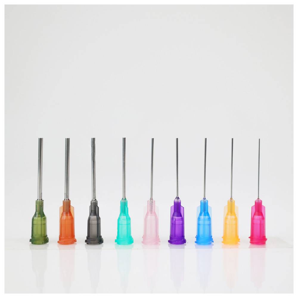 Neun farbenfrohe Spritznadeln, die in einer Reihe angeordnet sind, jede mit einem anderen farbigen Kanülenkopf: grün, orange, schwarz, blau, lila, rosa und hellblau.