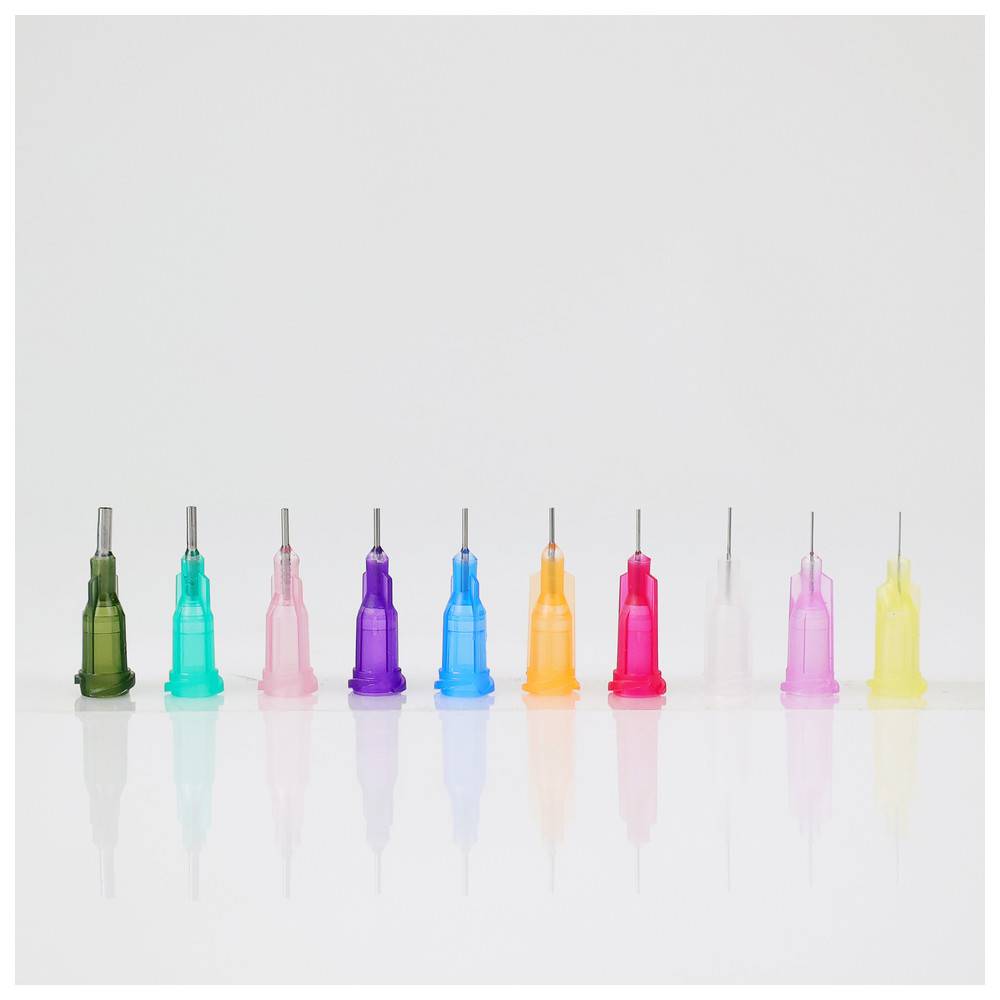 Zehn leuchtend bunte Spritzennadel-Schutzkappen sind in einer Reihe vor einem weißen Hintergrund angeordnet und zeigen verschiedene Schattierungen und Größen.