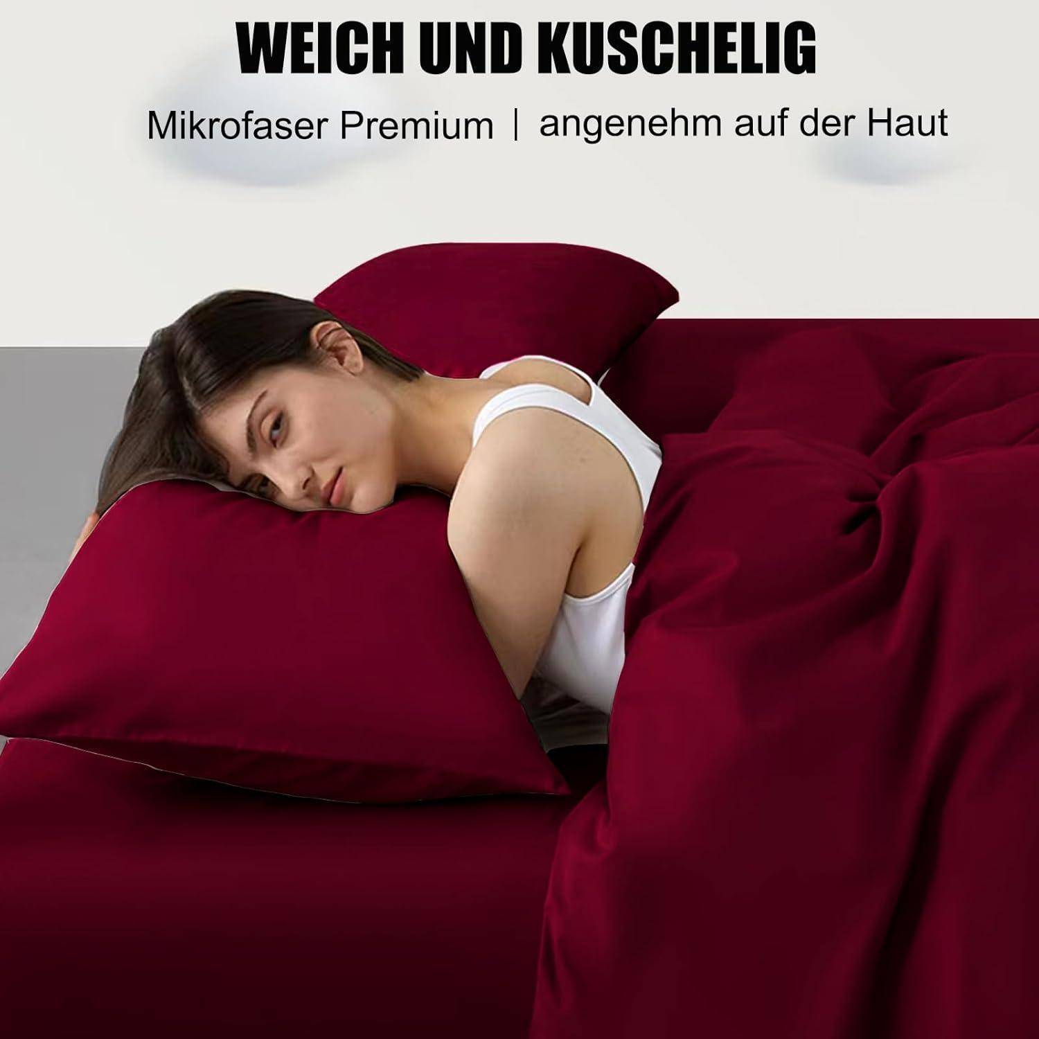 Eine Frau liegt gemütlich auf einem Bett mit dunkelroten Laken und Kissen. Der Text lautet: 'Weich und kuschelig - Mikrofaser Premium - angenehm auf der Haut.