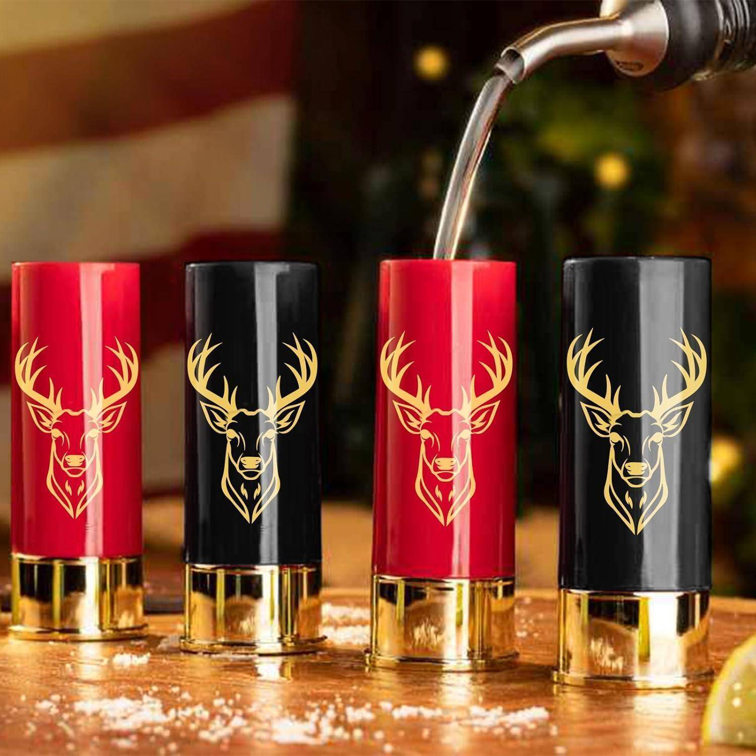 Vier Schrotflintenhülsen-förmige Schnapsgläser, zwei rote und zwei schwarze, zeigen einen goldenen Hirschkopf-Aufdruck. Eine Flüssigkeit wird in ein Glas gegossen.