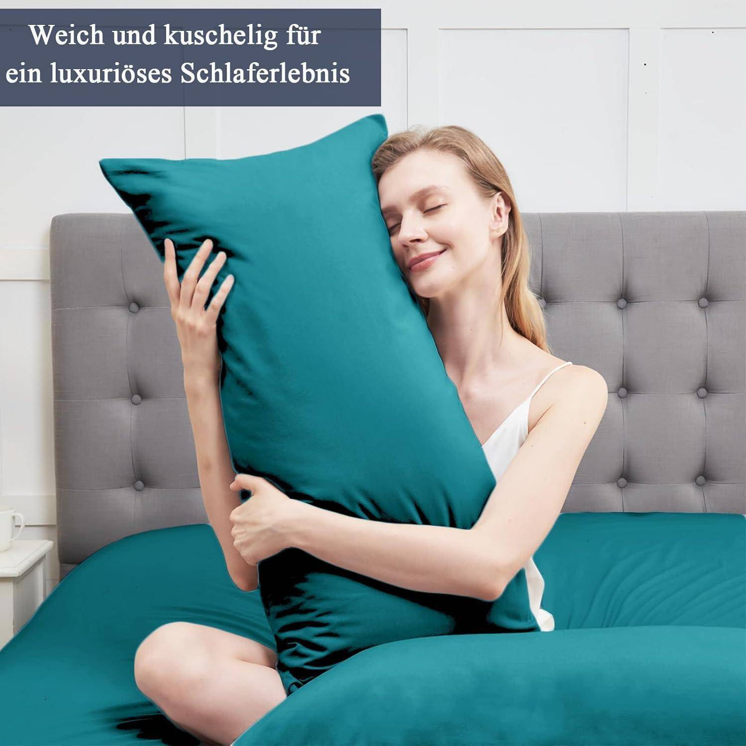 Eine Frau umarmt glücklich ein blaues Kissen, während sie auf einem Bett sitzt und Weichheit und Komfort ausstrahlt. Text: 'Weich und kuschelig für ein luxuriöses Schlaferlebnis.