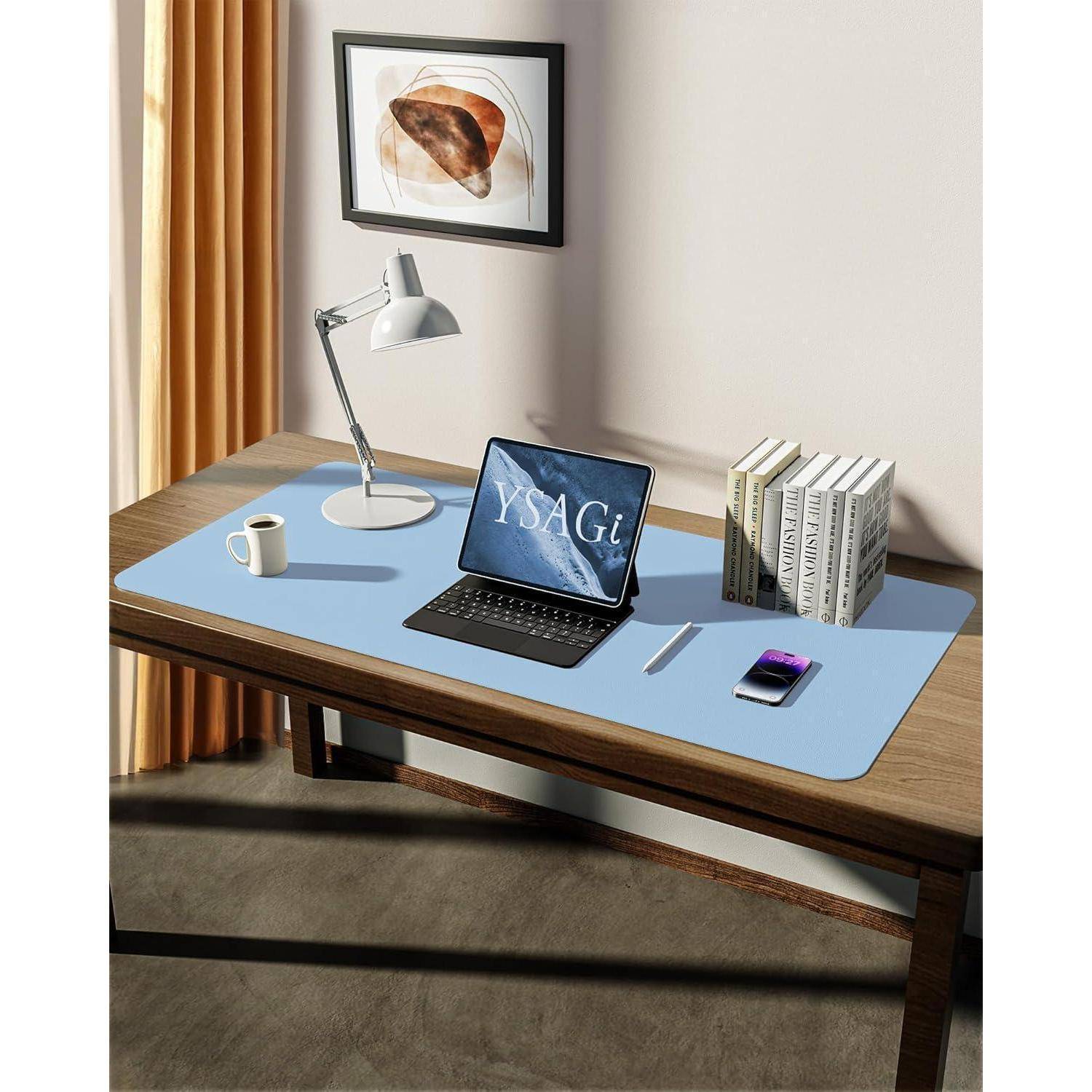 Ein Holzschreibtisch mit einer blauen Matte, einem Laptop mit der Anzeige 