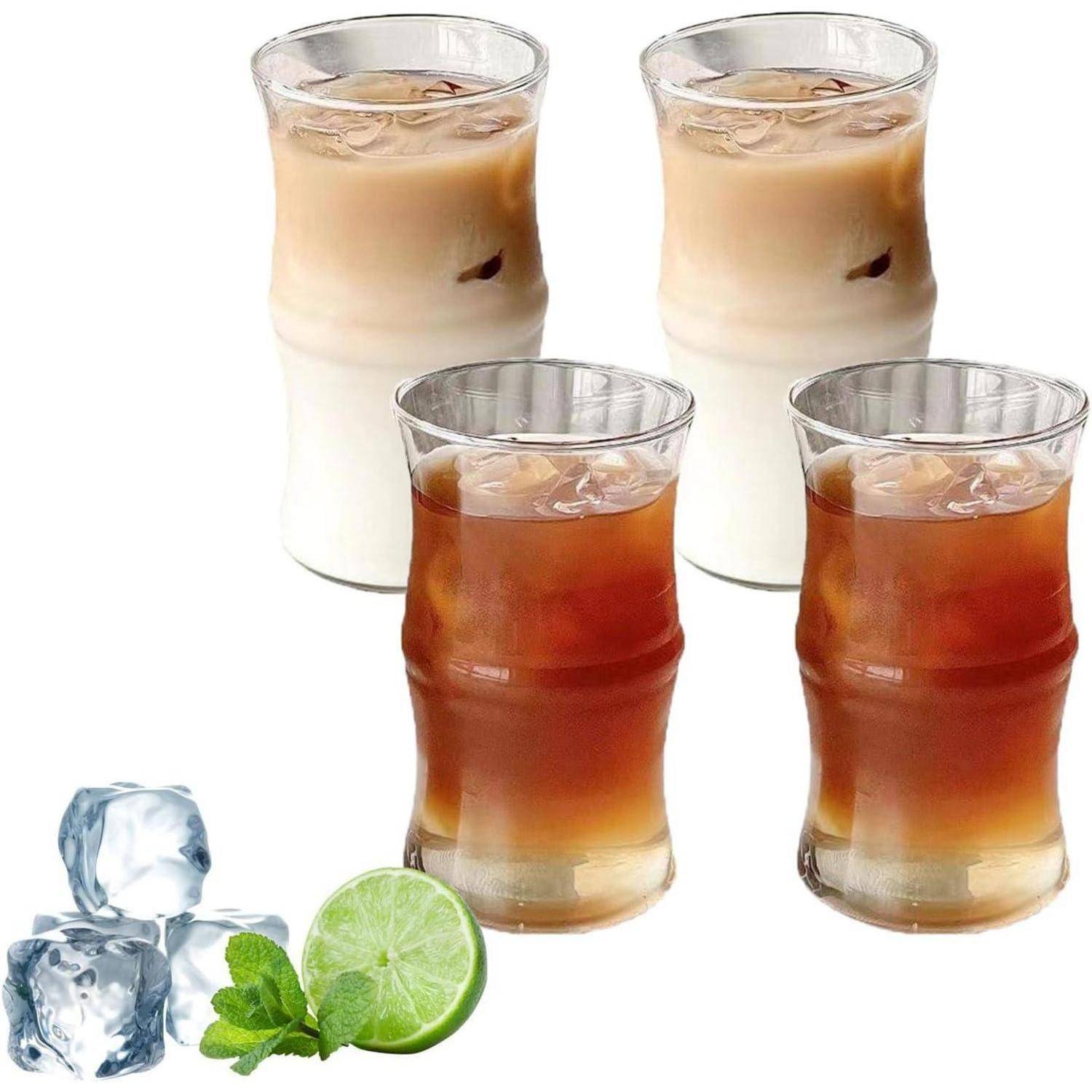 Drei Gläser Eiskaffee, zwei mit Milch und eines schwarz, neben Eiswürfeln, einer Limettenscheibe und Minzblättern.