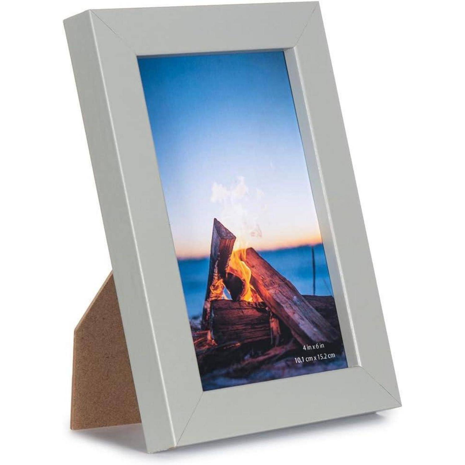 Ein Fotorahmen mit minimalistischem Design enthält ein Bild eines Lagerfeuers am Strand während des Sonnenuntergangs und erzeugt eine ruhige und warme Atmosphäre.