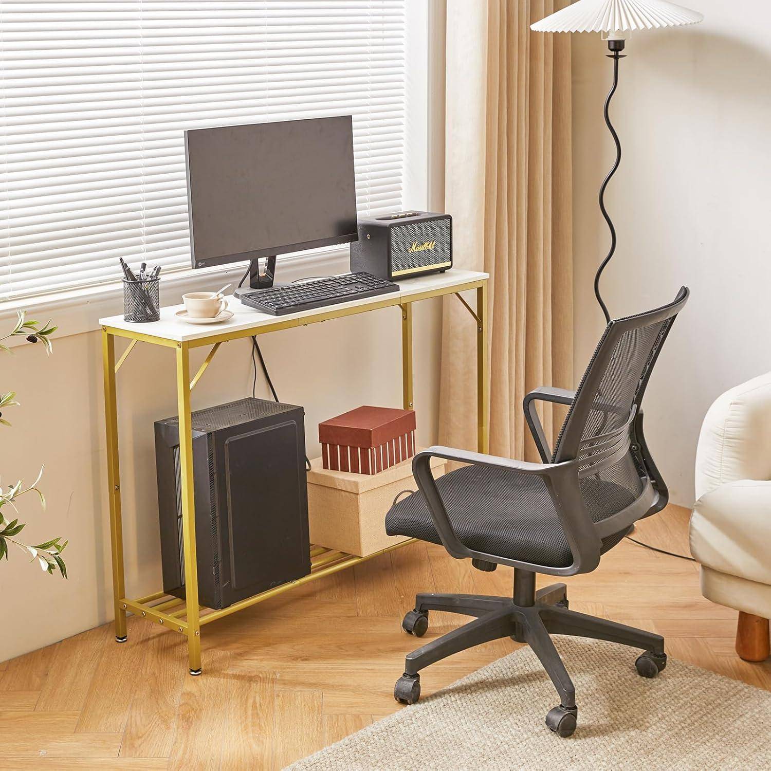 Ein aufgeräumter Home-Office-Arbeitsplatz mit einem Computermonitor auf einem Schreibtisch, einem Drehstuhl und einer hohen Stehlampe. Auf dem Schreibtisch befinden sich ein Lautsprecher und einige Bücher.