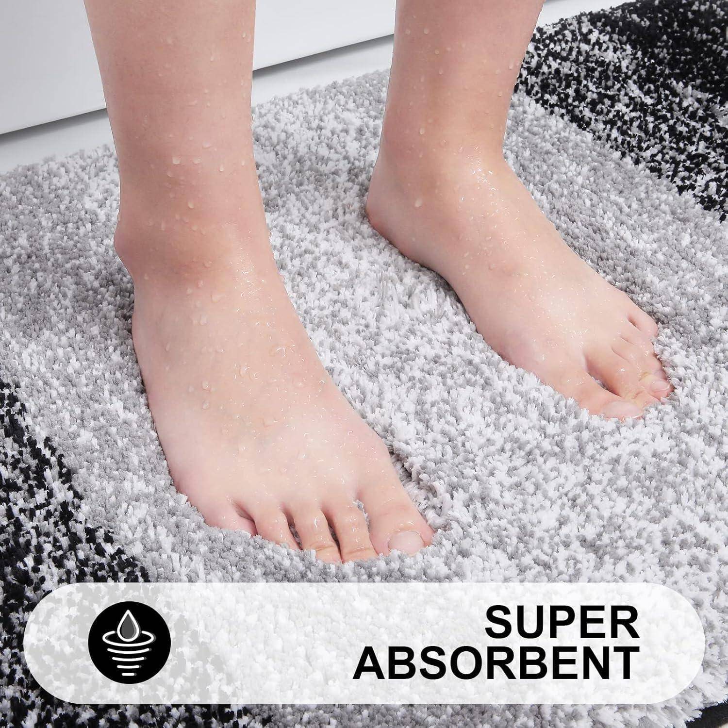 Nackte Füße auf einer grau-weißen Matte mit sichtbaren Wassertropfen. Der Text unten sagt ‚SUPER ABSORBIEREND' neben einem Wassertropfen-Symbol.