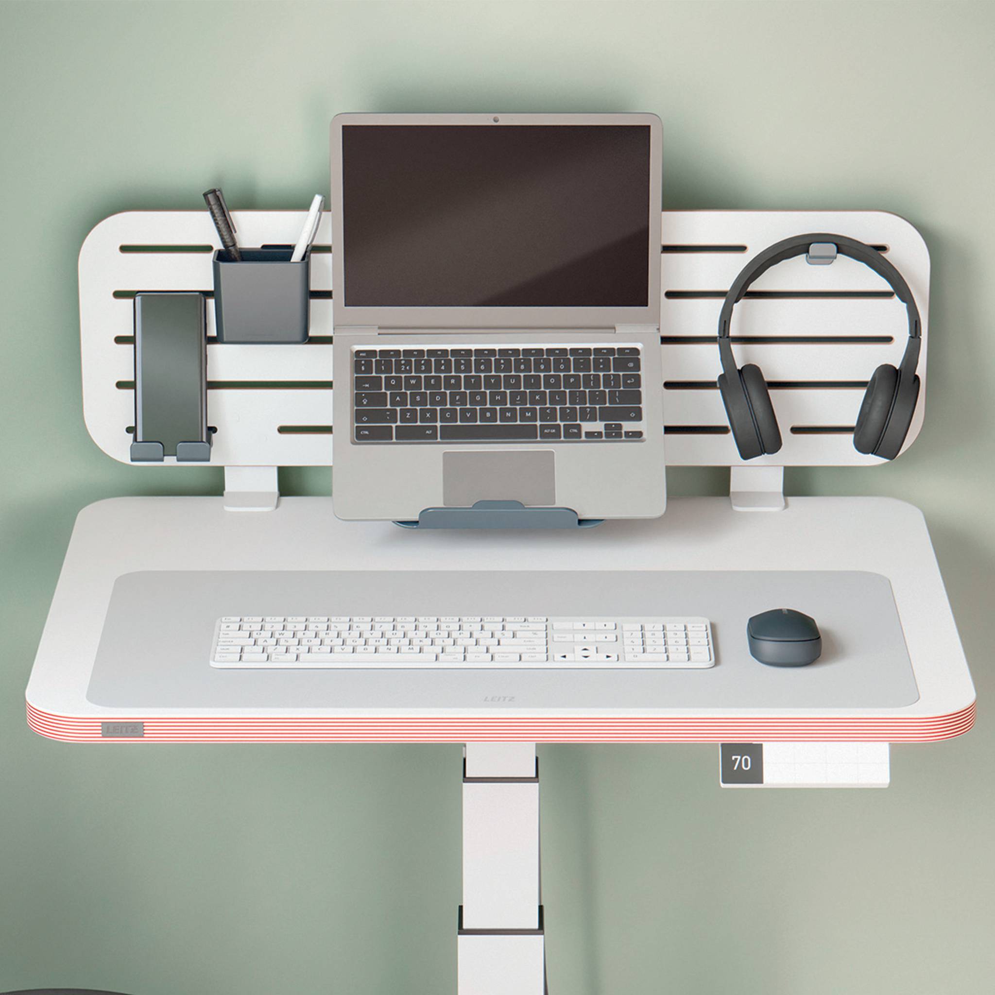 Draufsicht auf ein minimalistisches Schreibtisch-Setup mit einem Laptop auf einem Monitorständer, Tastatur, Maus, Kopfhörer und Telefon-Organizer auf einem weißen Schreibtisch.