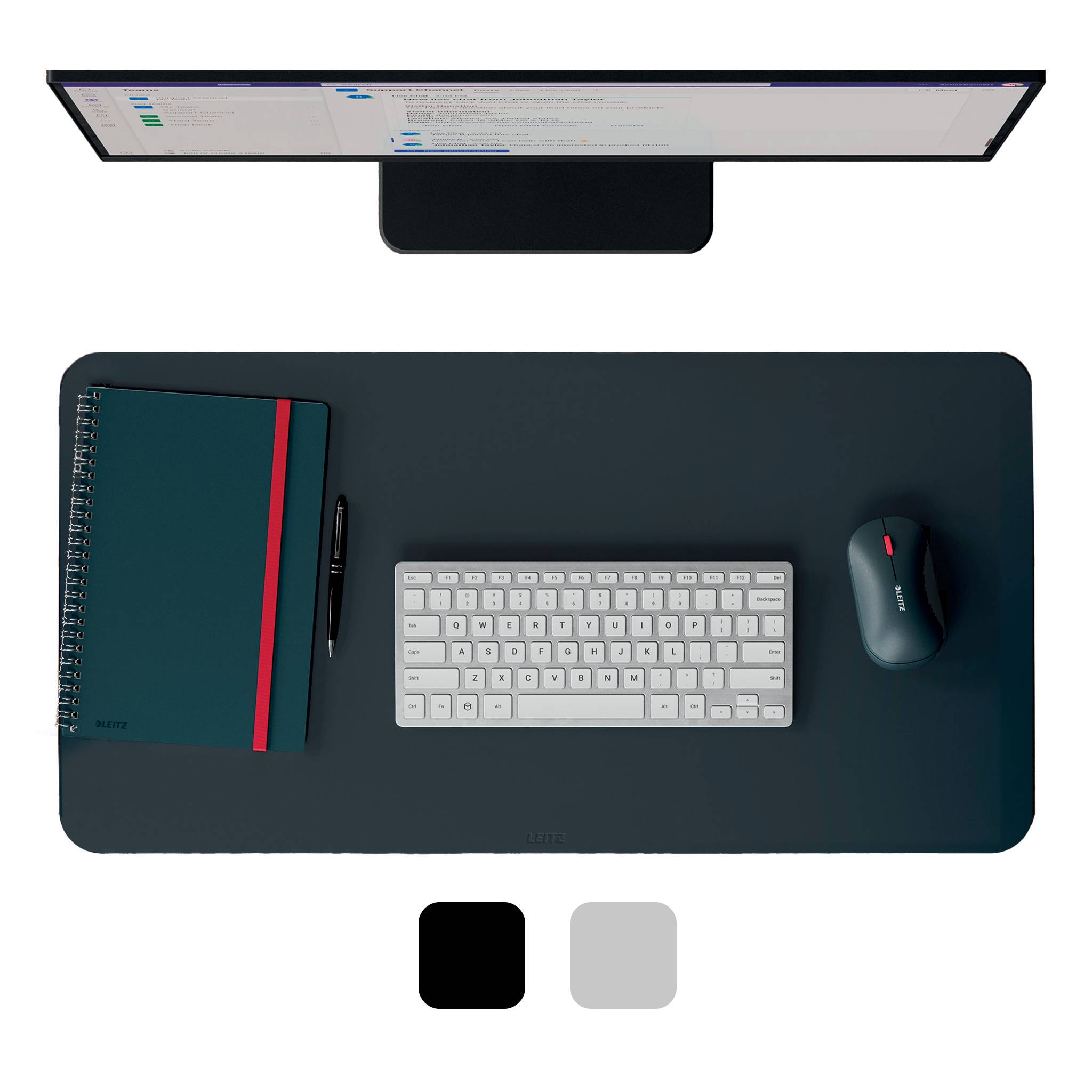 Draufsicht auf ein minimalistisches Desktop-Setup mit Monitor, Tastatur, Maus, Notizbuch und Stift auf einer dunklen Schreibtischunterlage.