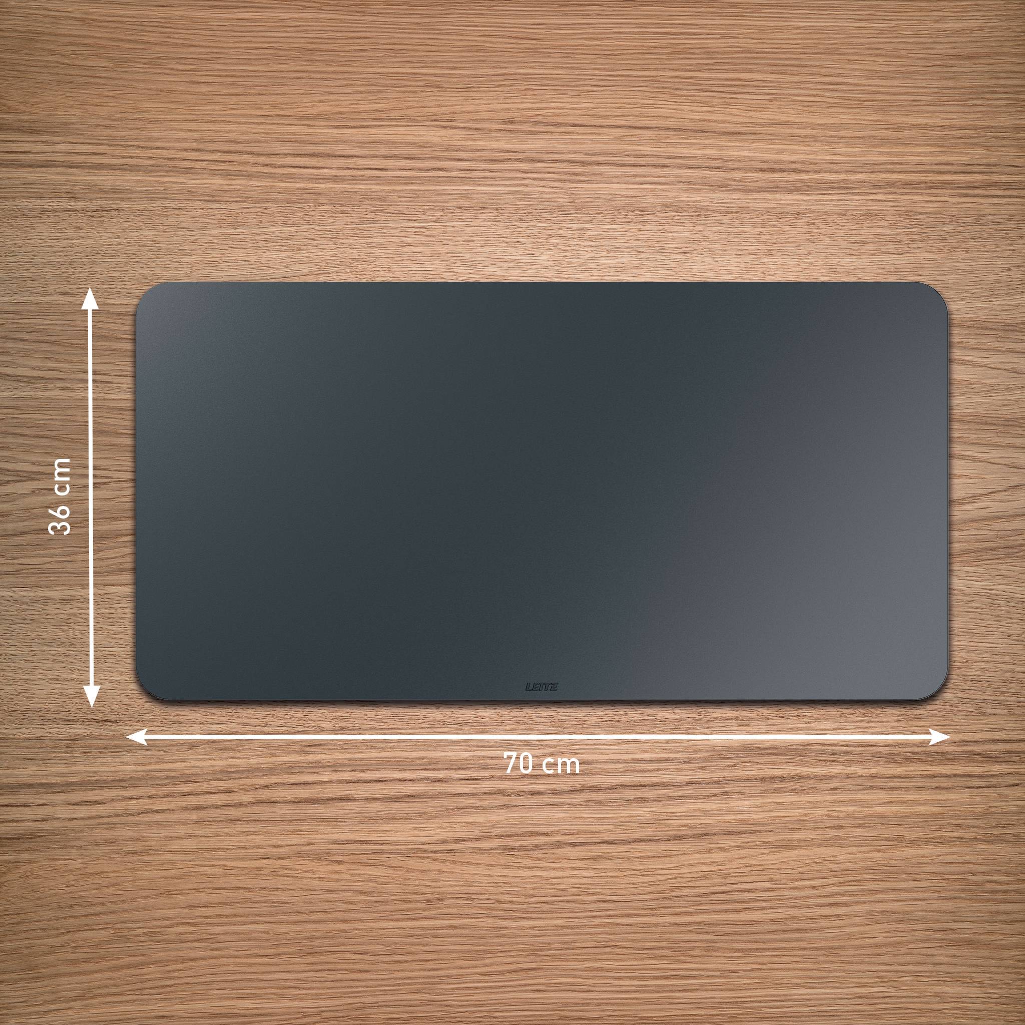 Rechteckiges schwarzes Mousepad auf einer Holzoberfläche, beschriftet mit 70 cm Breite und 36 cm Höhe mit Maßpfeilen.