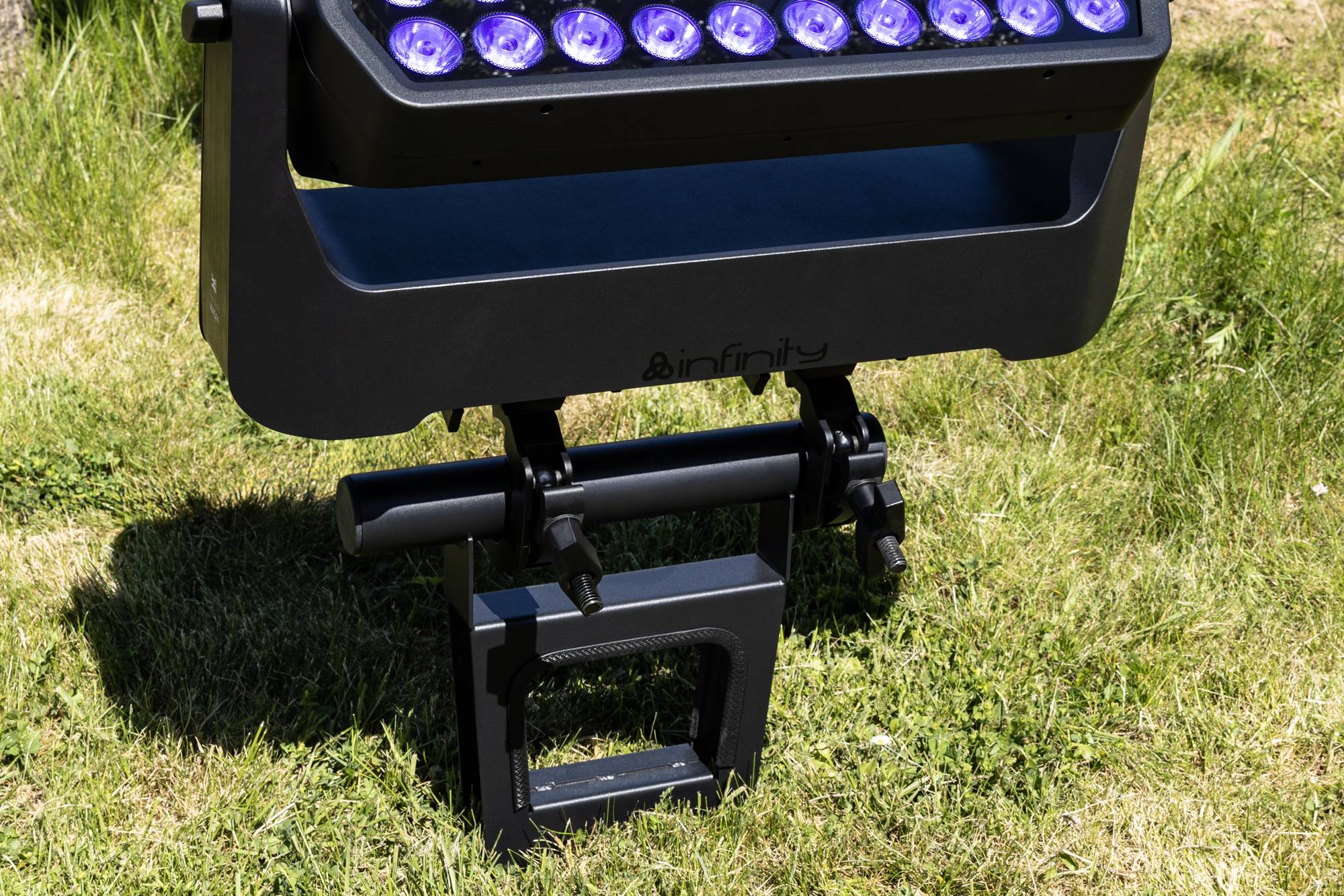 Eine schwarze LED-Außenleuchte mit mehreren lila Leuchtmitteln steht auf einer Rasenfläche und präsentiert ihr Design und ihre Funktionalität.