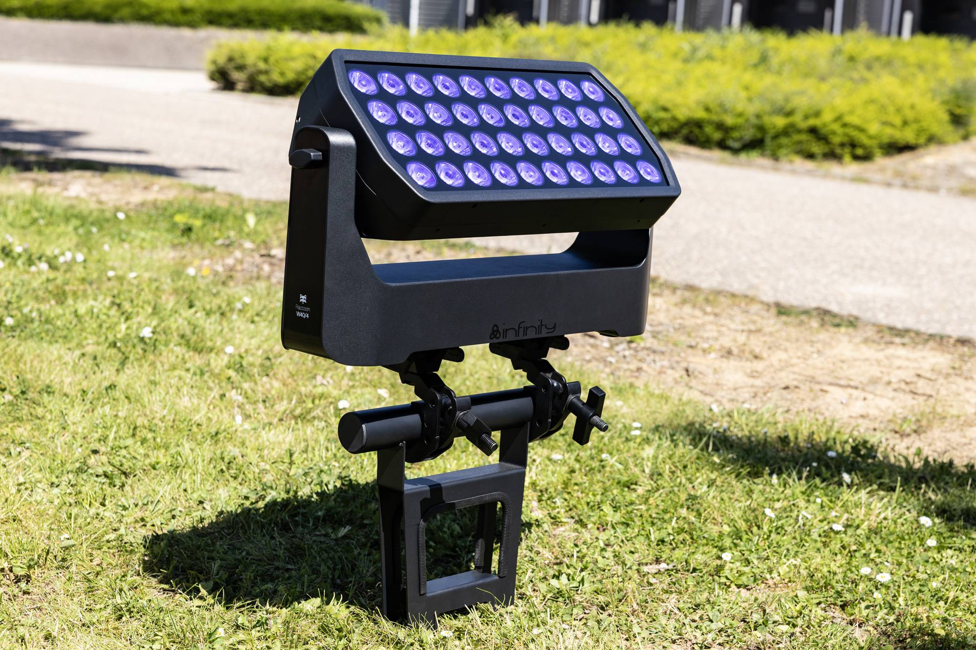 Eine schwarze Außenleuchte mit LED-Lampen ist in einem Parkrasen montiert und leuchtet nach oben.