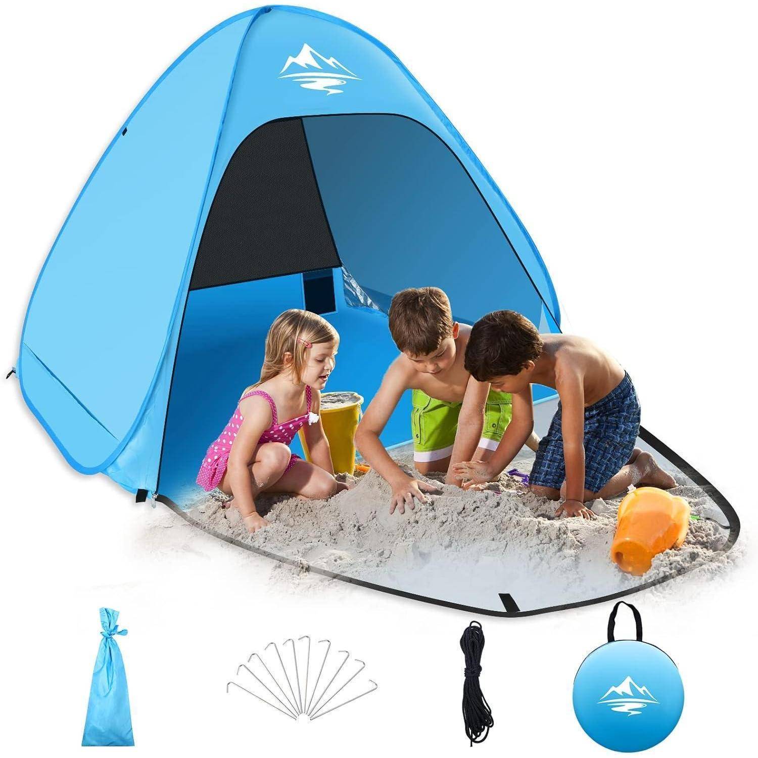 Kinder spielen im Sand unter einem blauen Pop-up-Zelt mit einem Berglogo. Zubehör umfasst Heringe, Seil, Tragetasche und Aufbewahrungsbeutel.