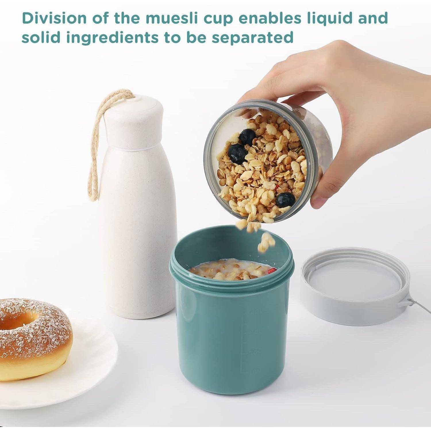 Eine Hand gießt Müsli mit Blaubeeren in eine blaue Tasse. In der Nähe stehen eine Flasche und ein Donut. Der Text lautet: „Die Teilung der Müslitasse ermöglicht die Trennung von flüssigen und festen Zutaten.