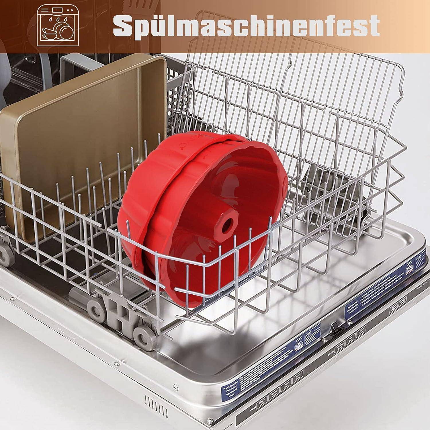 Geöffnete Spülmaschine mit einer roten Backform und einem braunen Backblech innen. Der deutsche Text 'Spülmaschinenfest' weist auf geschirrspülmaschinengeeignete Gegenstände hin.